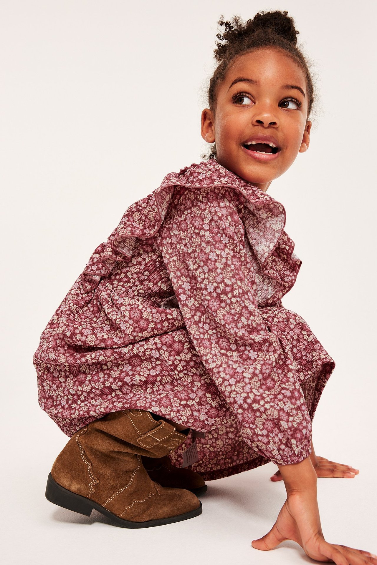 Widok z przodu: dziecko w bordowej, kwiecistej sukience z krepy i dżerseju z falbankami, brązowe kozaki.