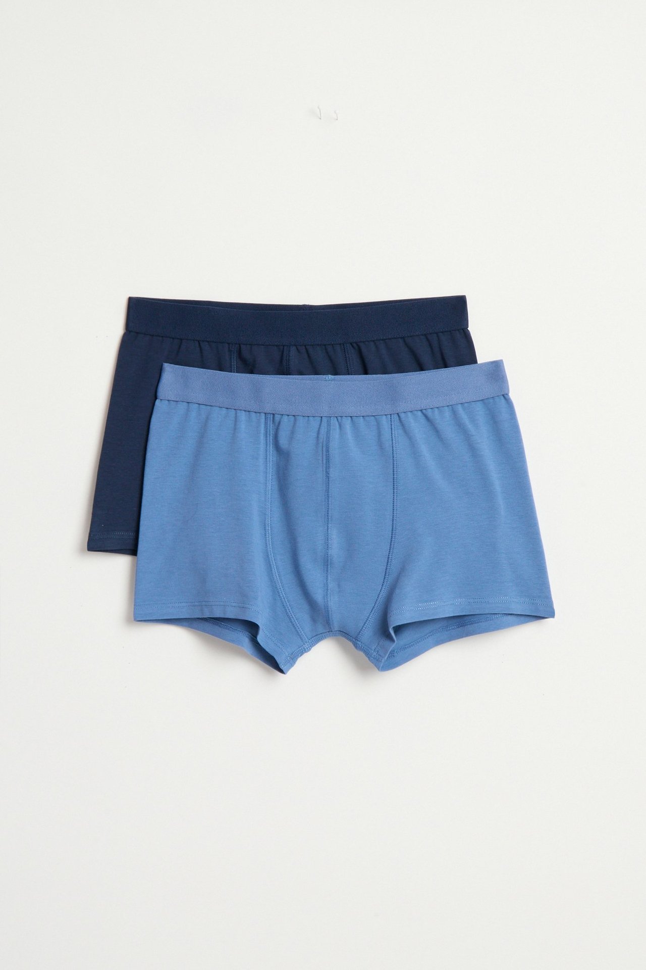 Widok z przodu: Dziecięce jasnoniebieskie bawełniane bokserki z elastycznym pasem, z ciemnoniebieską parą z tyłu.