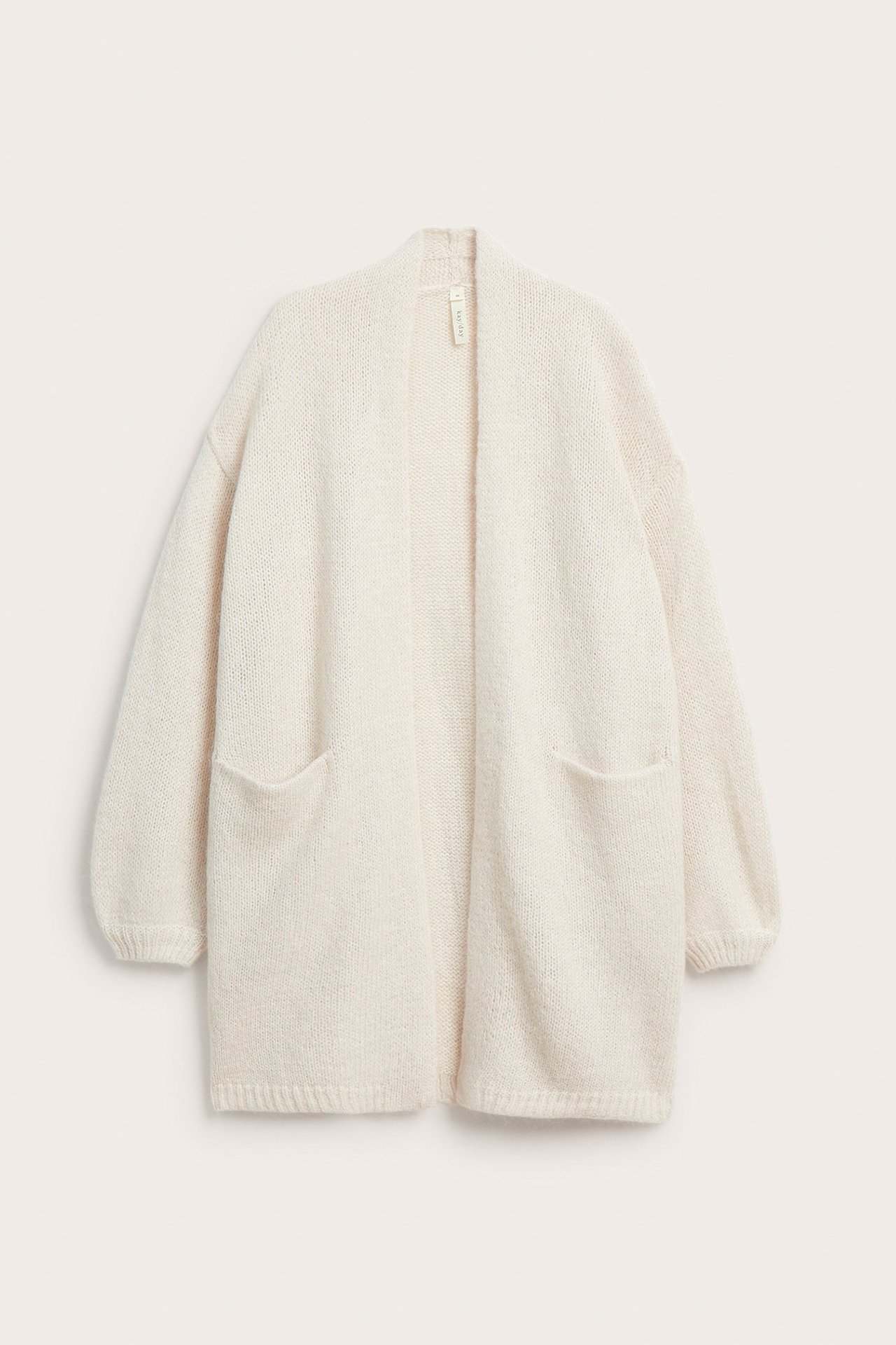 Forfra: Lys beige cardigan i ullblanding med sjalkrage, ribbestrikkede mansjetter og to lommer.