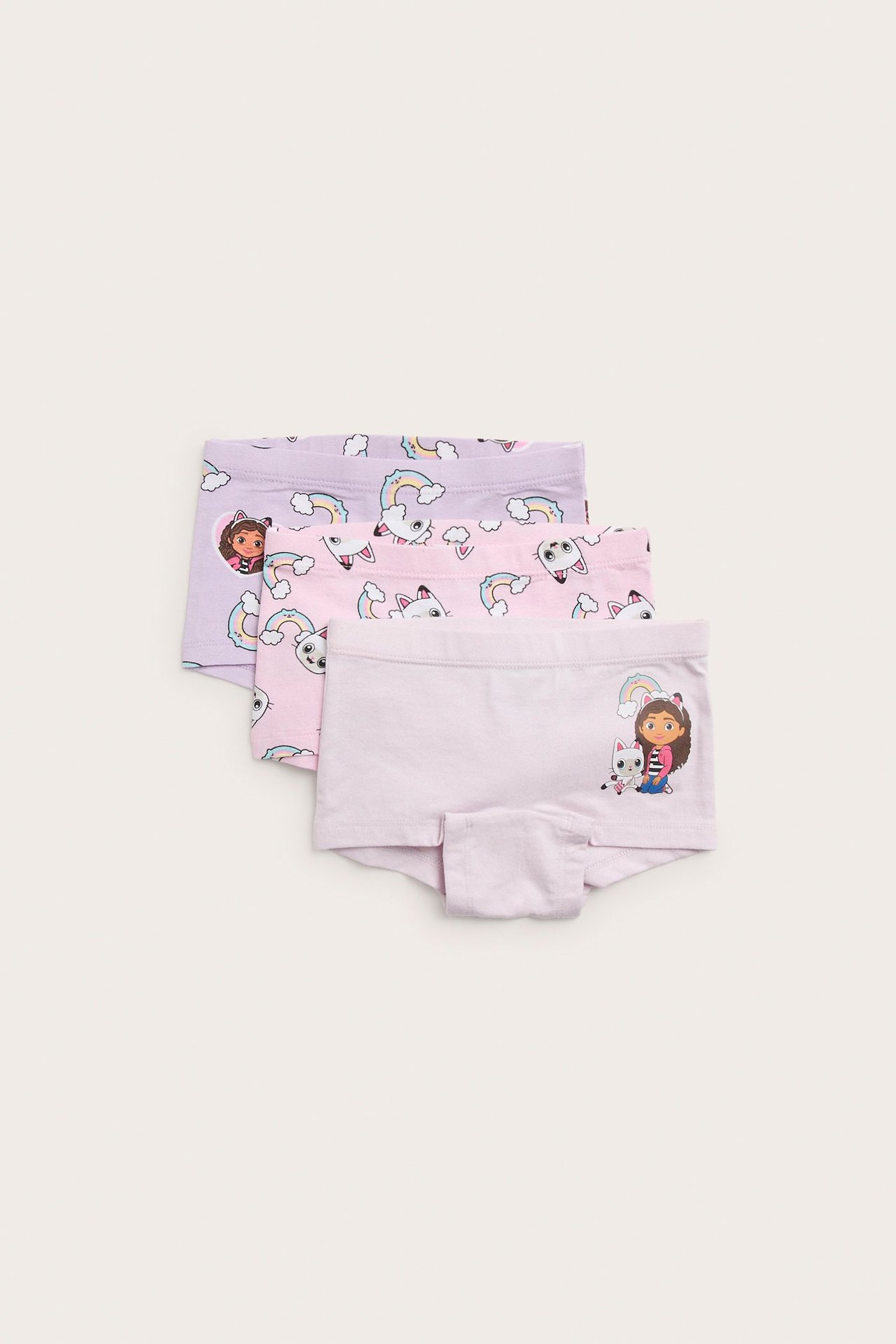 Widok z przodu trzech bokserek dziecięcych: jasnofioletowe z nadrukiem Gabby's Dollhouse, dwie wzorzyste.