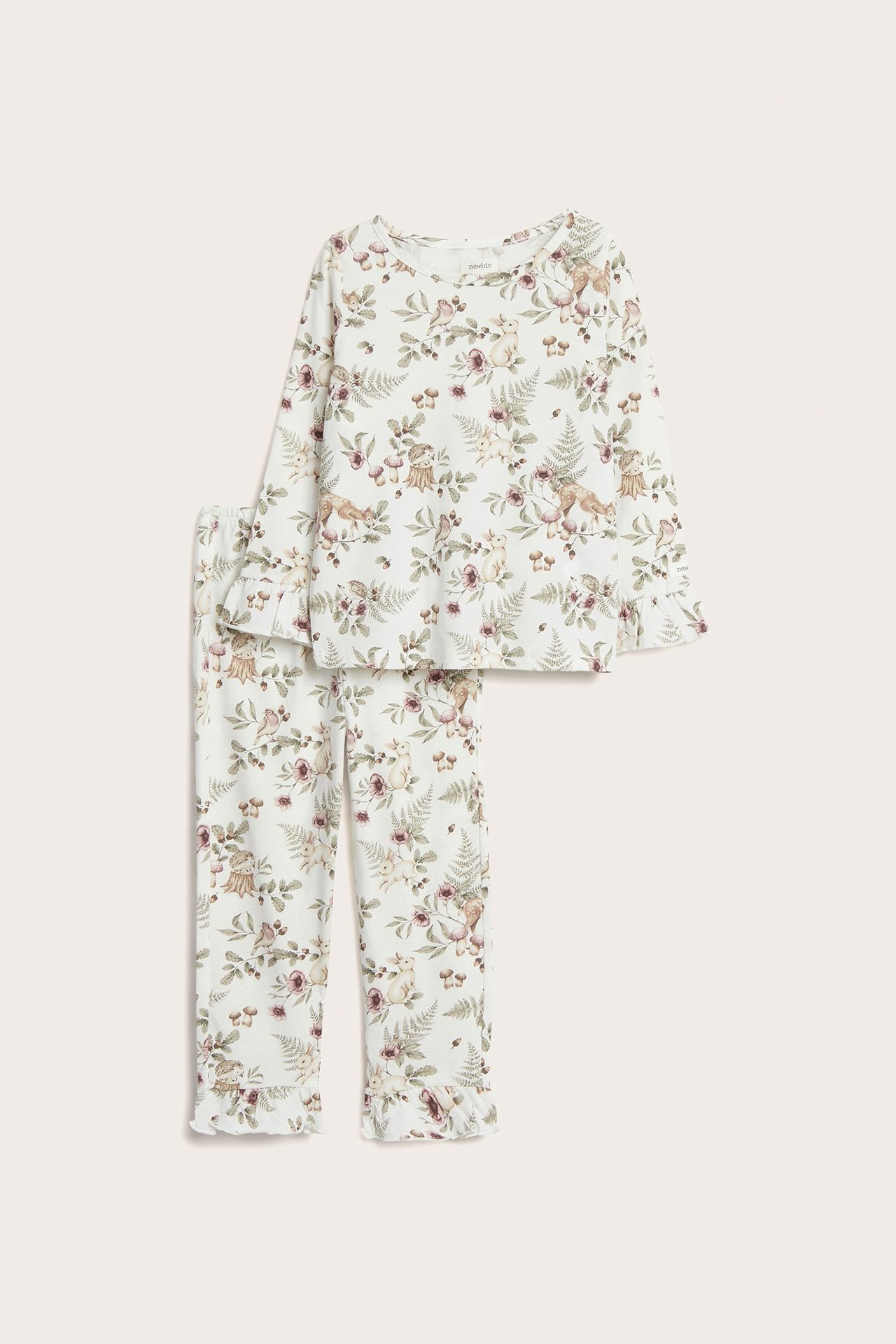 Edestä näkymä lasten luonnonvalkoisesta puuvillapyjamasta, jossa kukkia ja metsäneläimiä, röyhelöillä.