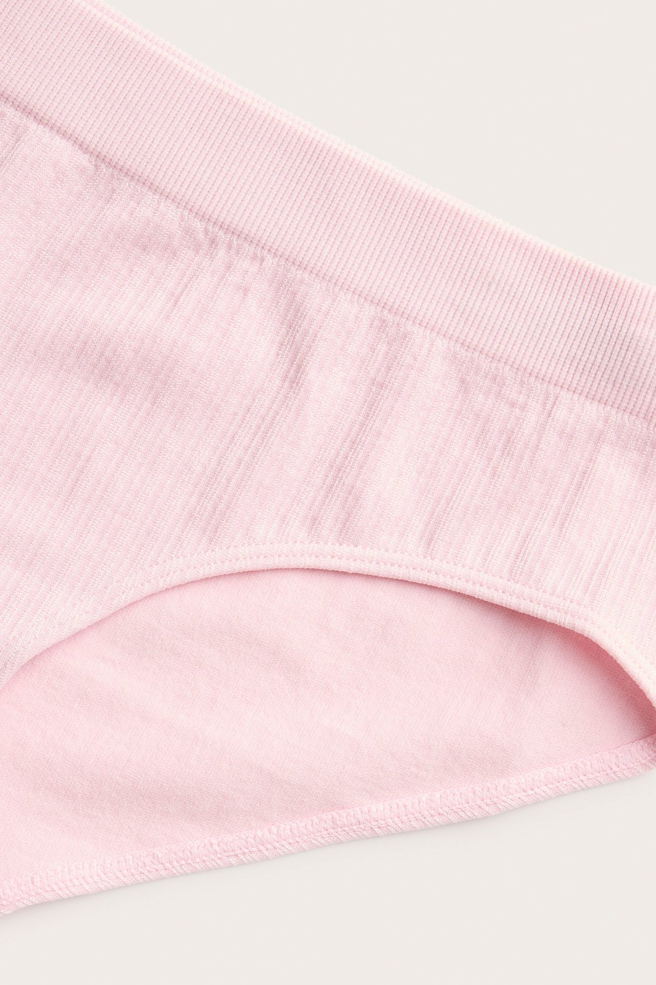 Nærbilde av rosa ribbet hipster-truse, som viser den ribbete teksturen og ensfargede designen.