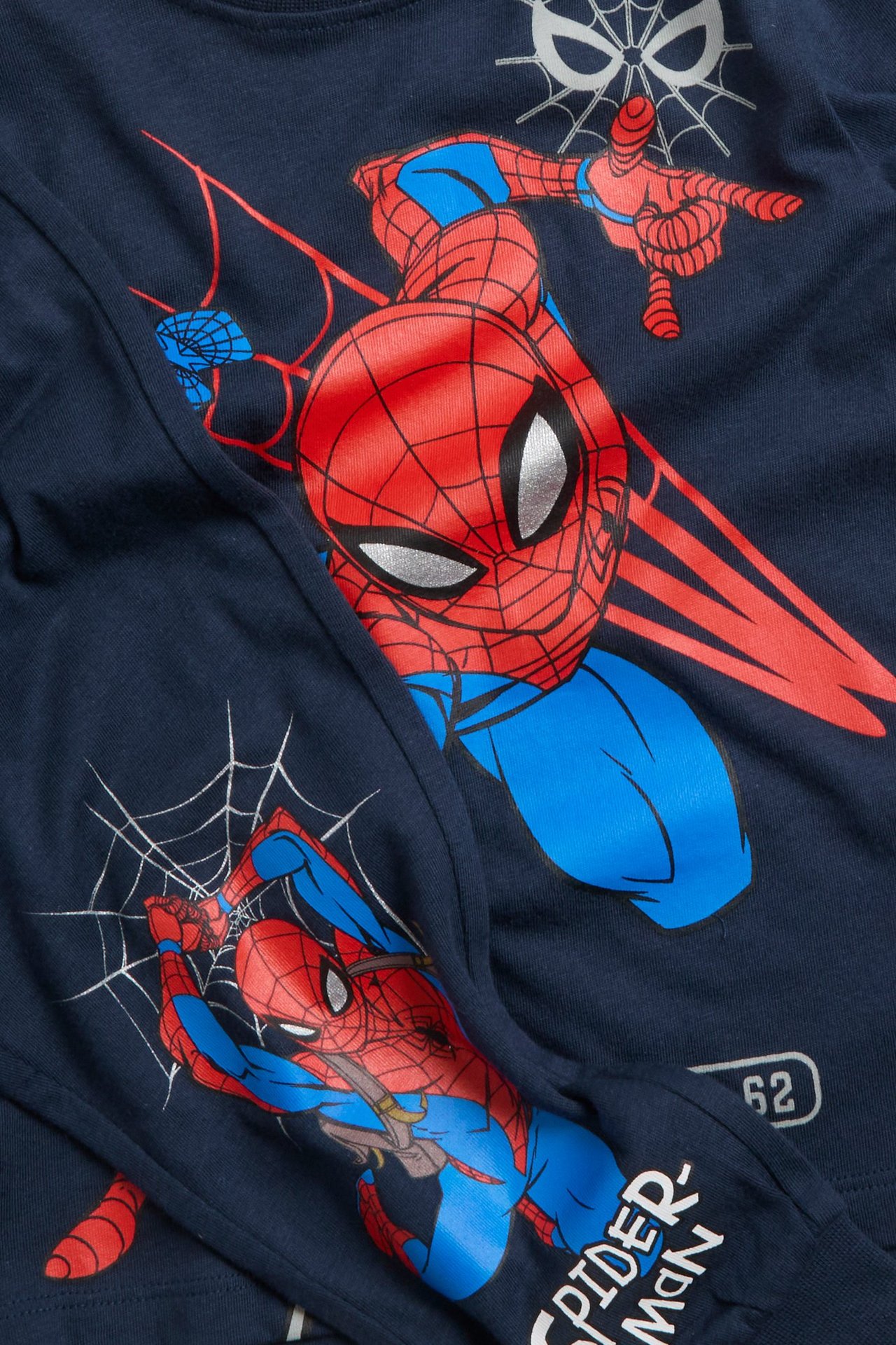 Lähikuva lasten tummansinisestä puuvillapyjamasta, jossa on suuri Hämähäkkimies-painatus.