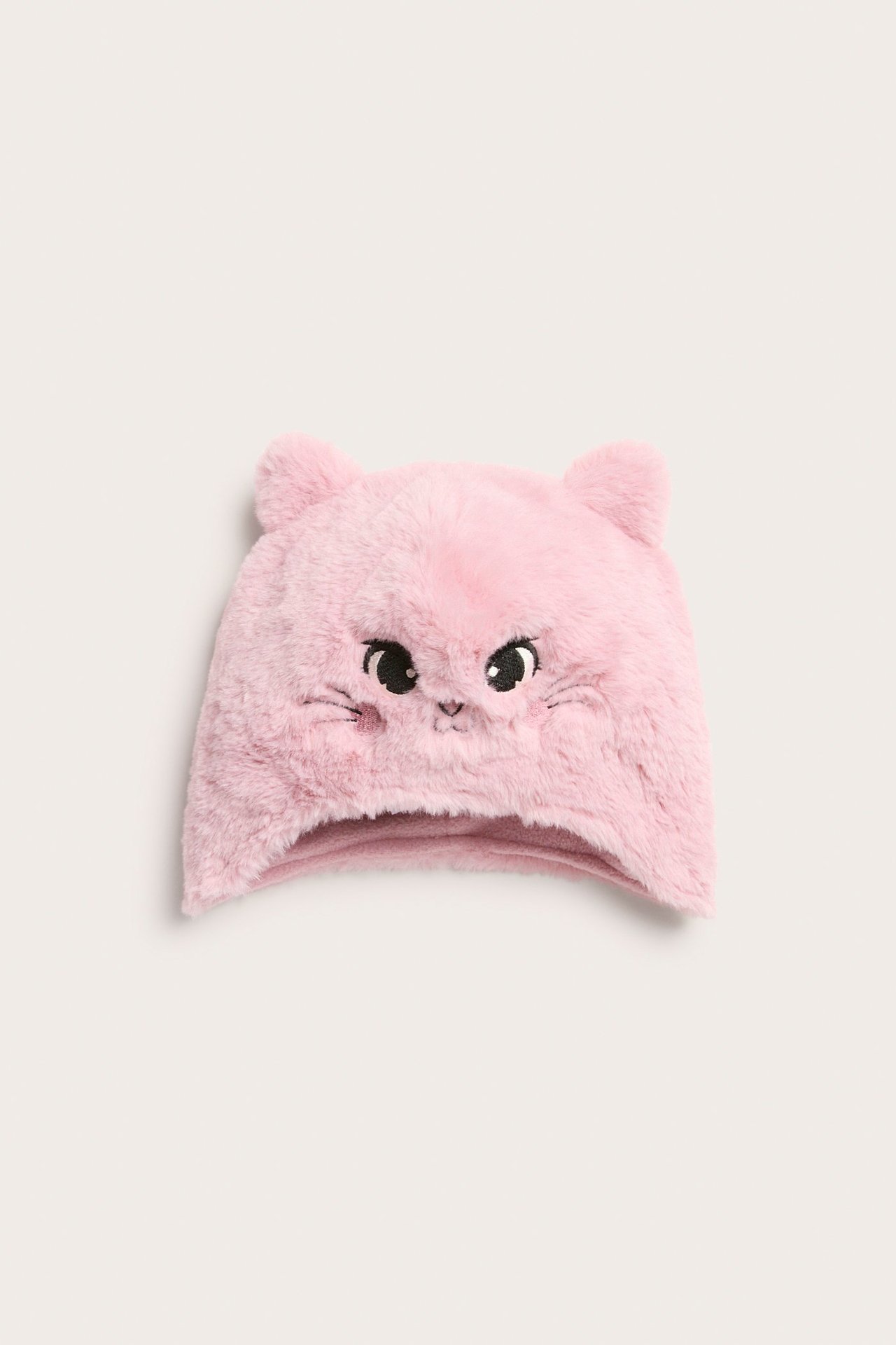 Widok z przodu: jasnoróżowa puszysta czapka ze sztucznego futra dla dzieci z uszami i haftowaną twarzą kota.