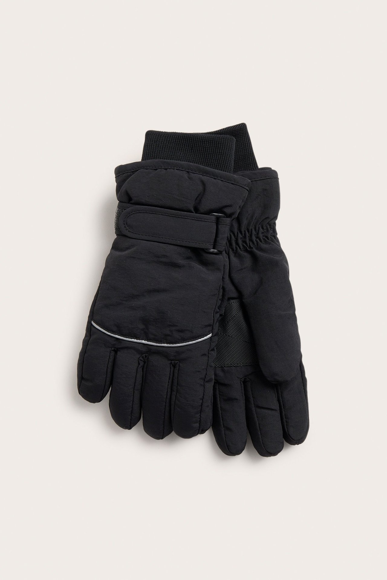 Edestäpäin, mustat lasketteluhanskat, joissa resorit, säädettävät rannehihnat ja heijastinnauha.