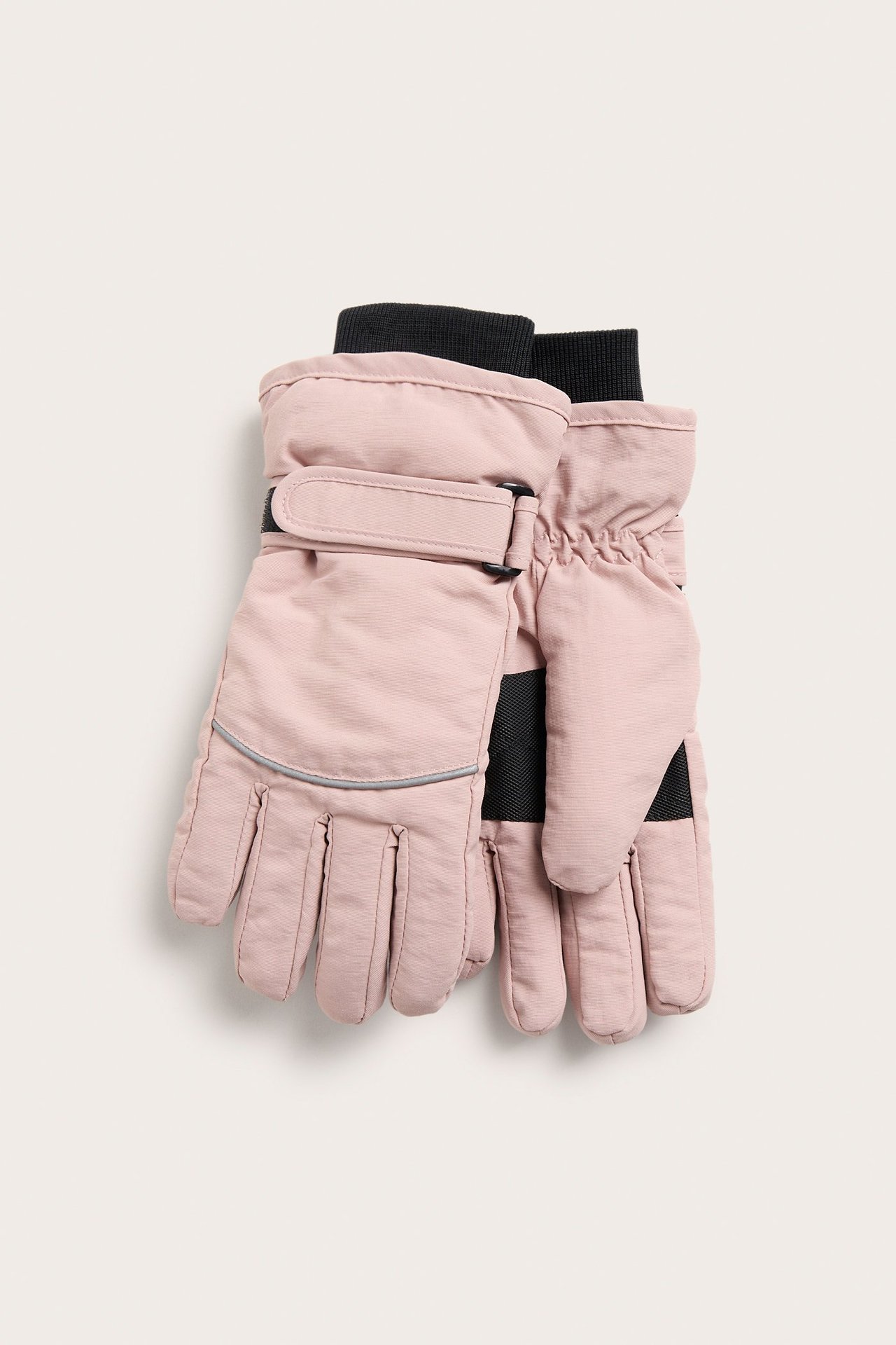 Edestä näkymä vaaleanpunaisista lasketteluhanskoista, joissa mustat resorit ja säädettävät rannehihnat.