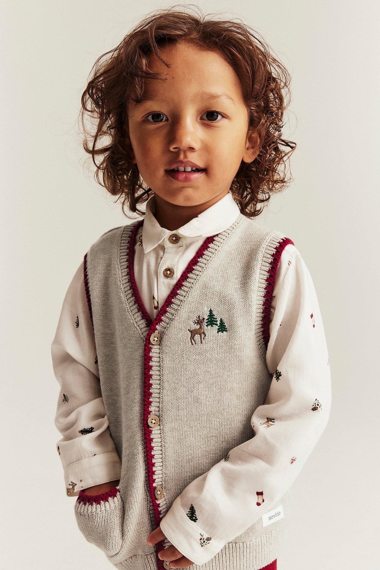 Lapsi valkoisessa paidassa ja beige melange jouluhameessa brodyrillä ja taskulla, etunäkymä.