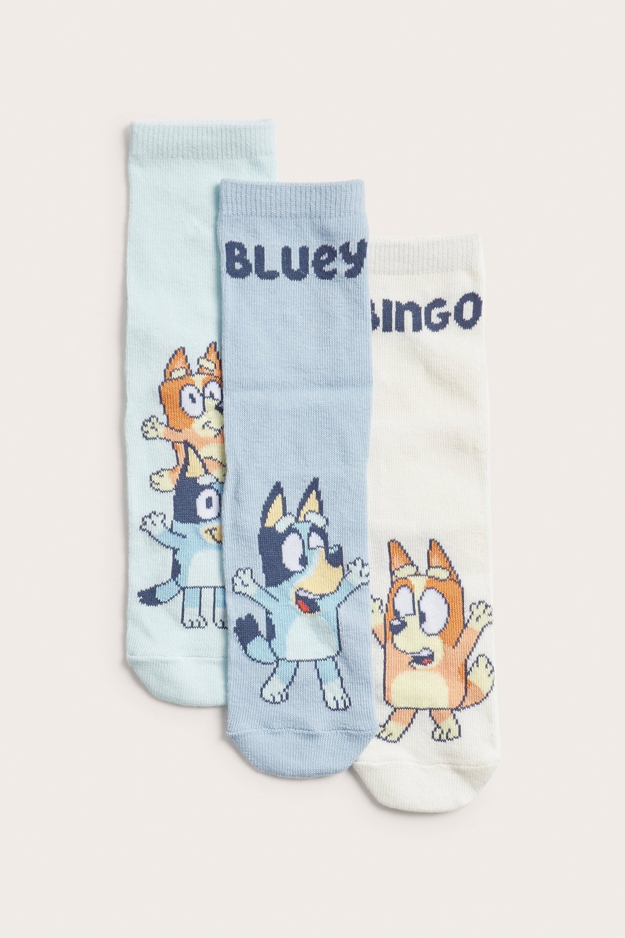 Edestä: Kolme paria lasten puuvillasukkia Bluey-kuvioilla vaaleansinisenä, sinisenä ja luonnonvalkoisena.