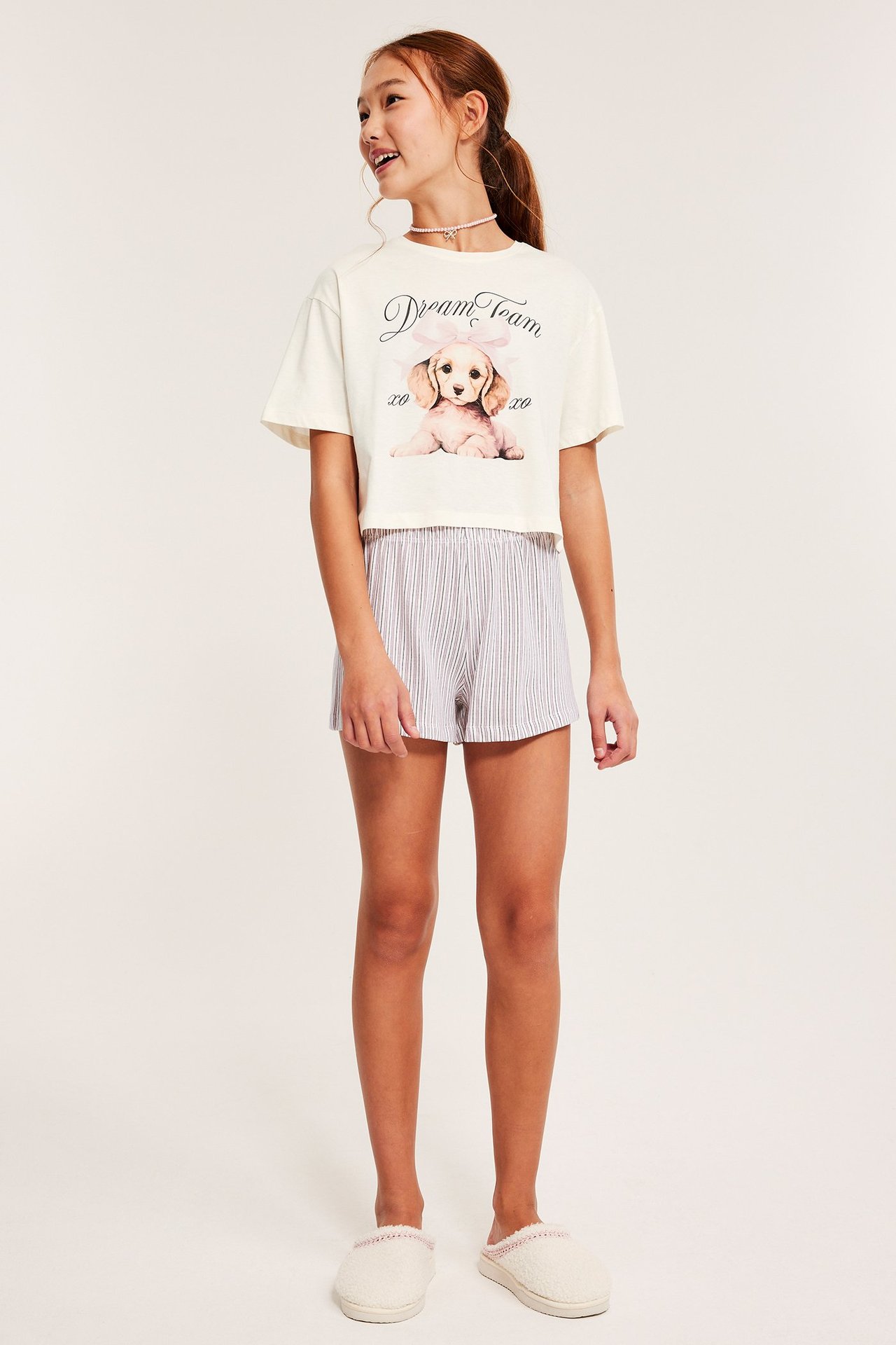 Harmaa lyhythihainen pyjama, etupainatus, raidalliset shorts, nainen, rento tyyli.