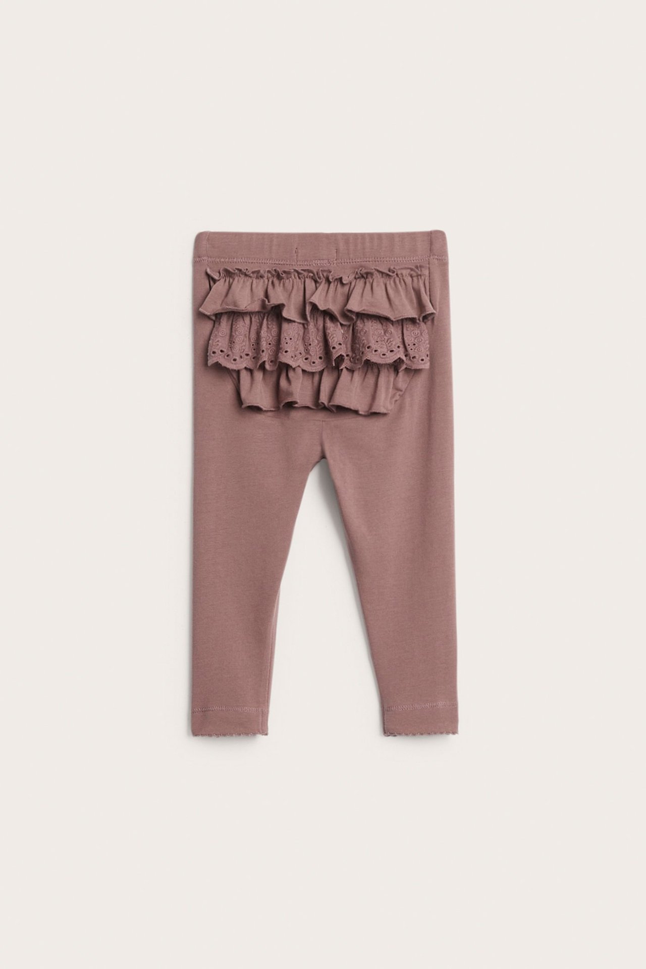 Frontvisning av babyens mørkrosa bomullsleggings med volanger og blondedetalj bak.