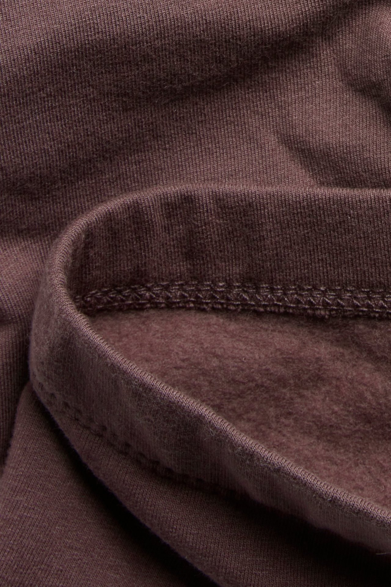 Zbliżenie na liliowy materiał bawełnianych legginsów, ukazujące prążkowaną stronę zewnętrzną i miękki, szczotkowany spód.