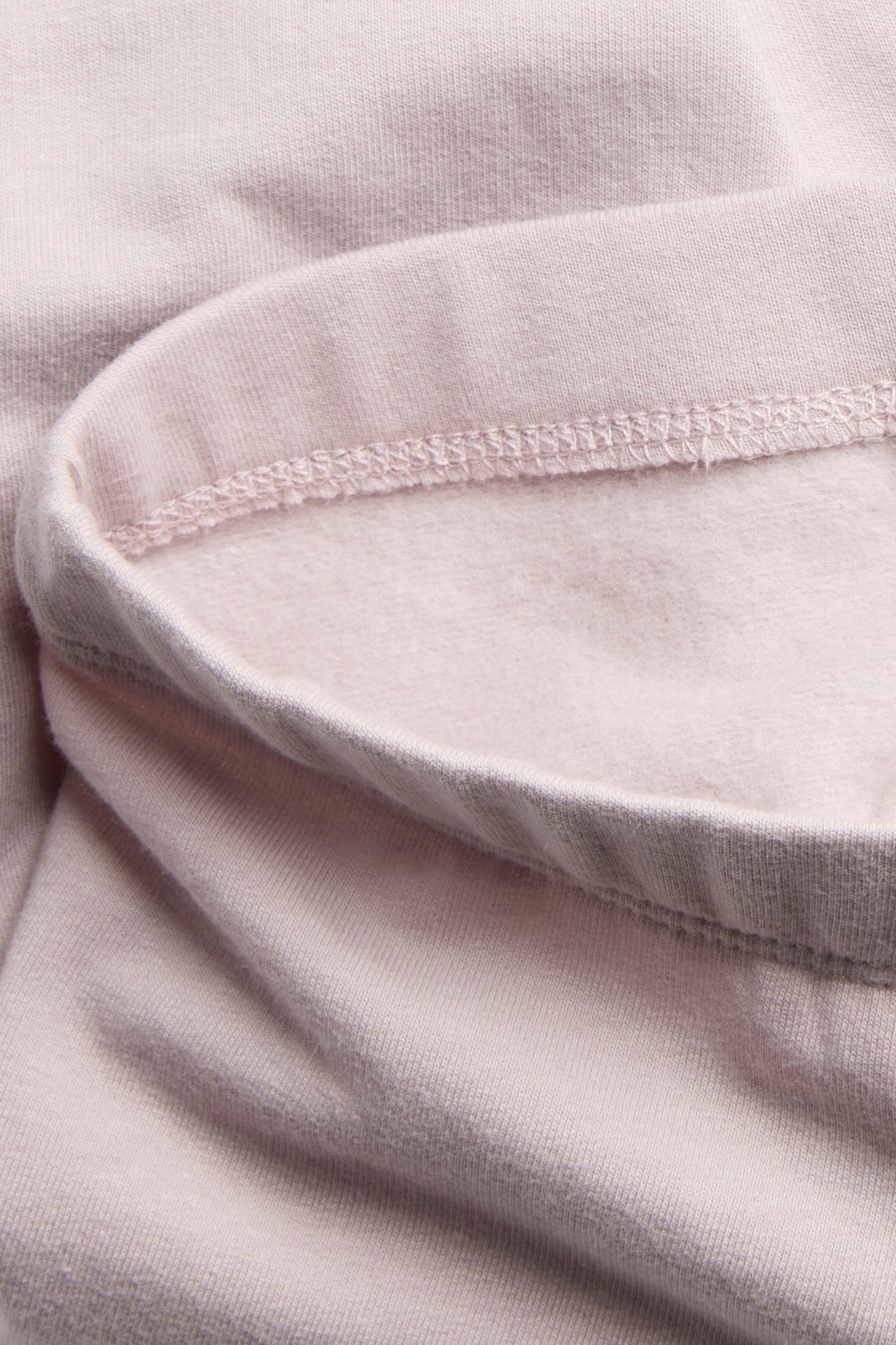 Lähikuva paksusta vaaleanlilan leggingsien kankaasta, jossa harjattu sisäpuoli.