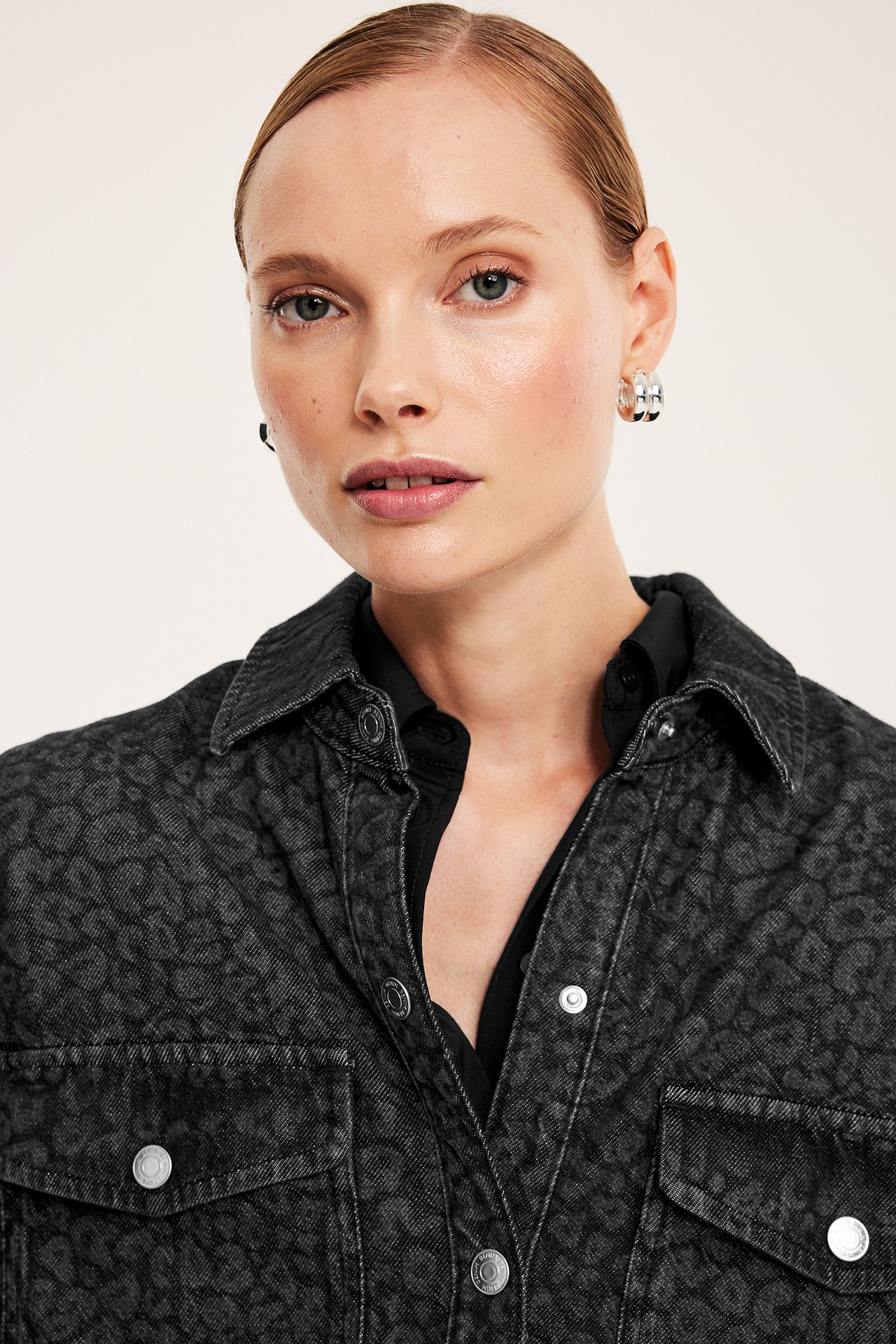 Kvinnemodell i grå denimskjorte med leopardmønster, frontvisning.