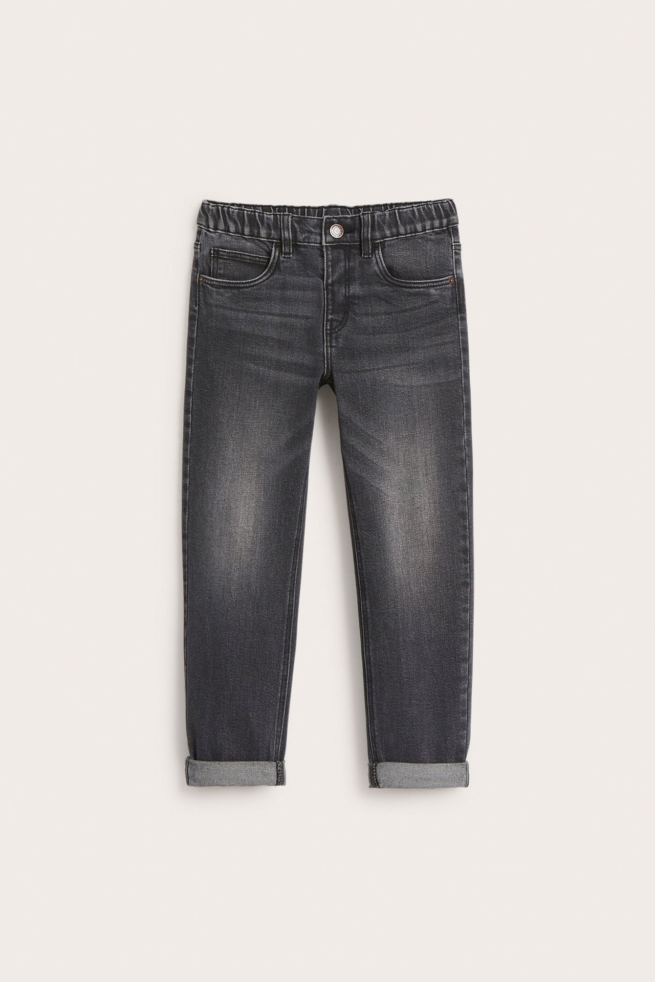 Frontvisning av grå relaxed fit jeans for barn med elastisk midje og oppbrettede benkanter.