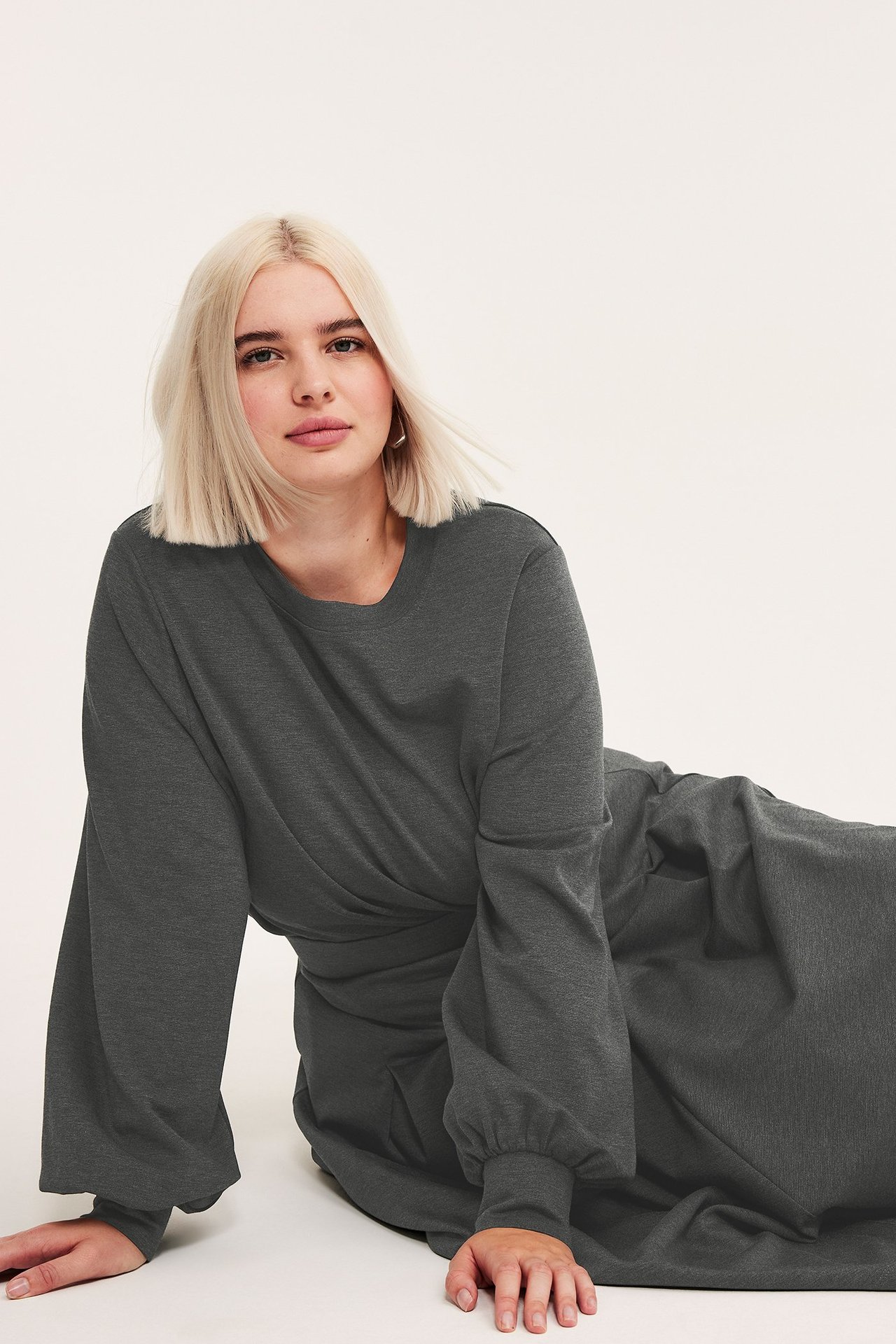 Widok z przodu kobiety w ciemnoszarej melanżowej bluzie z bufiastymi rękawami i pasującymi spodniami.