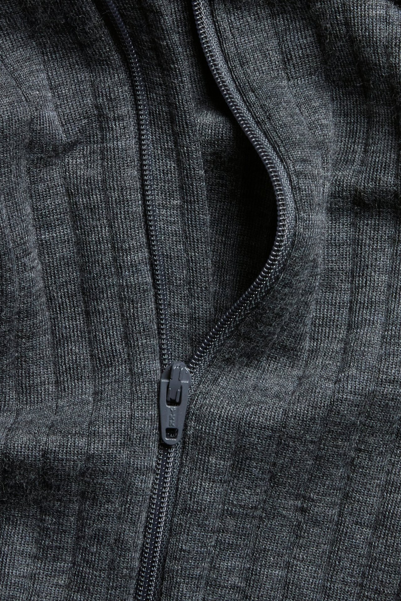 Zbliżenie na szary melanżowy prążkowany materiał z wełny merynosów z ciemnoszarym zamkiem.