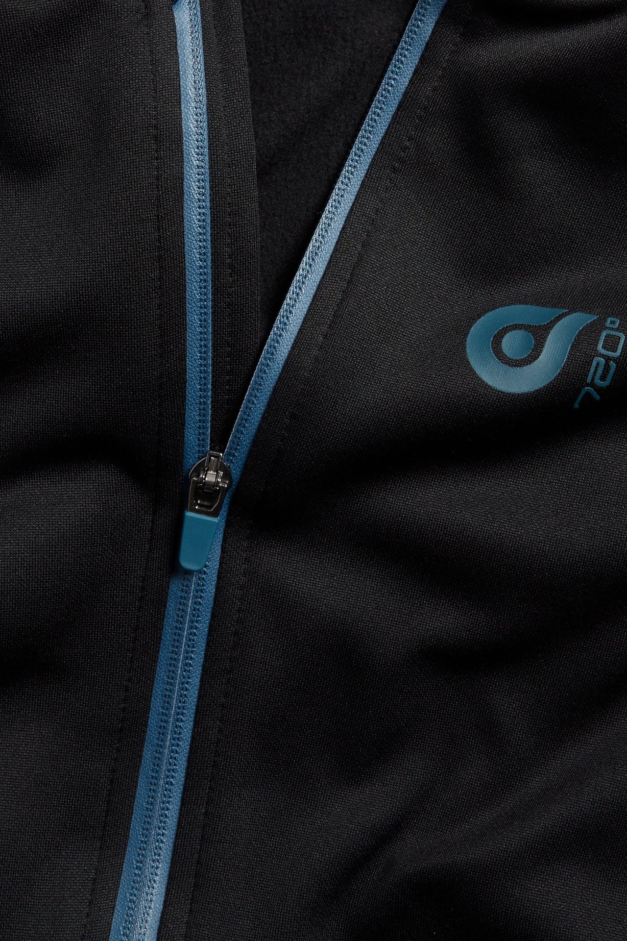 Zbliżenie czarnej poliestrowej bluzy z kapturem z niebieskim zamkiem i logo na piersi.