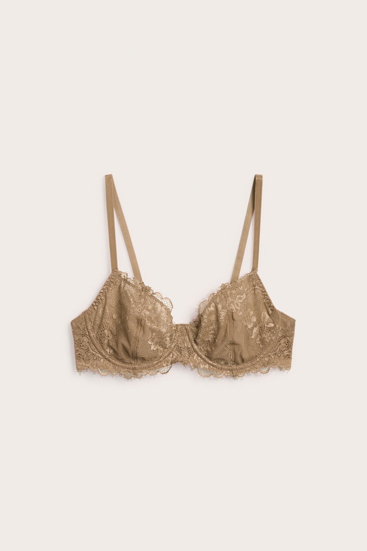 Edestä kuvattu beige topaton kaarituellinen rintaliivi, jossa on läpikuultavaa pitsiä ja kimaltavat olkaimet.