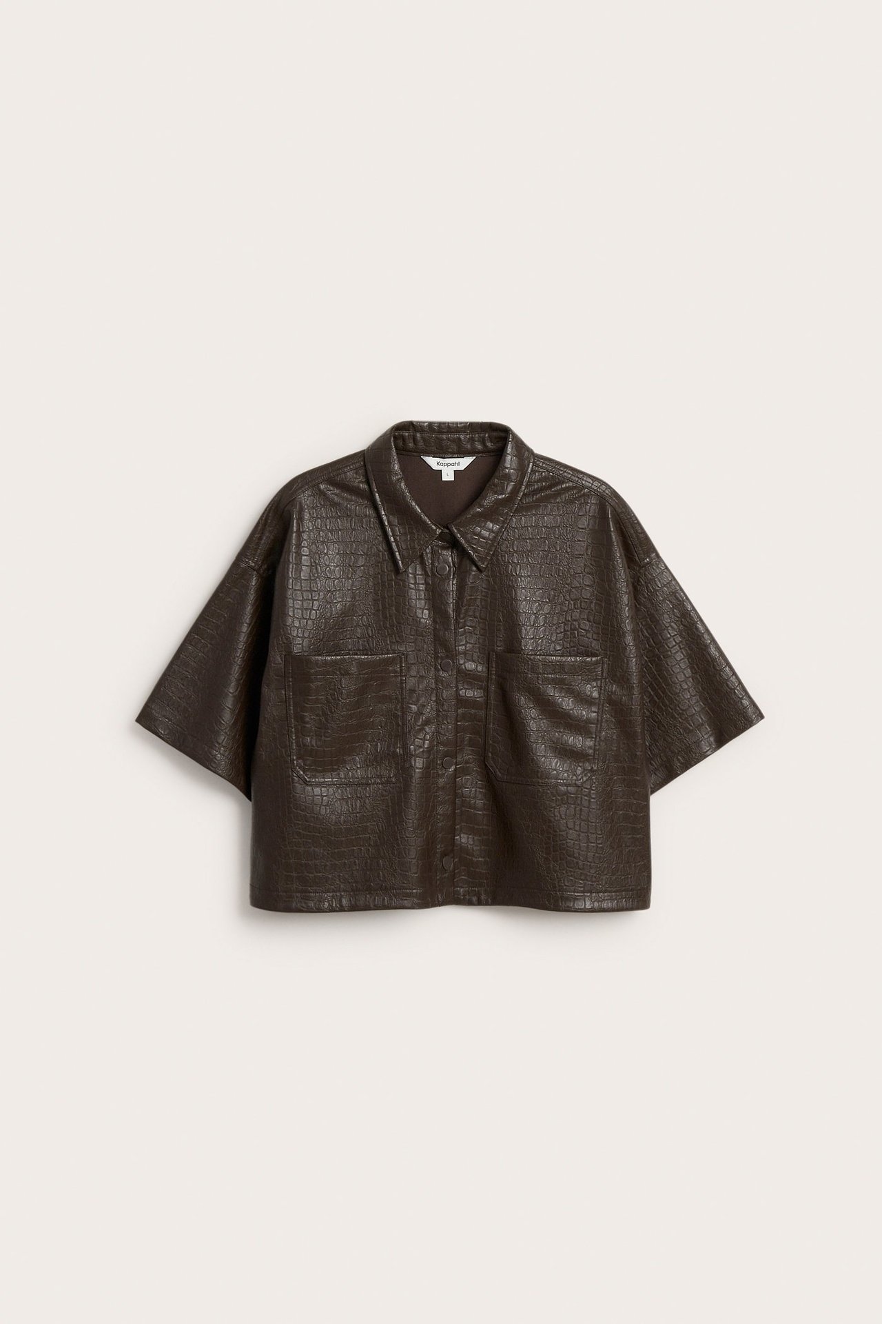 Edestäpäin näkymä tummanruskeasta tekokonahkaisesta lyhythihaisesta paidasta, jossa on krokotiilikuosi ja rintataskut.