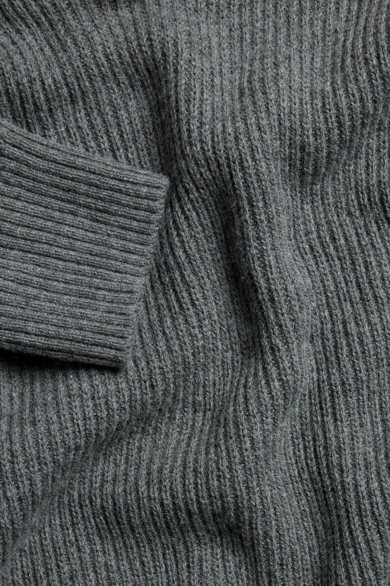Zbliżenie ciemnoszarego melanżowego swetra z dzianiny o prążkowanej fakturze i ściągaczu.