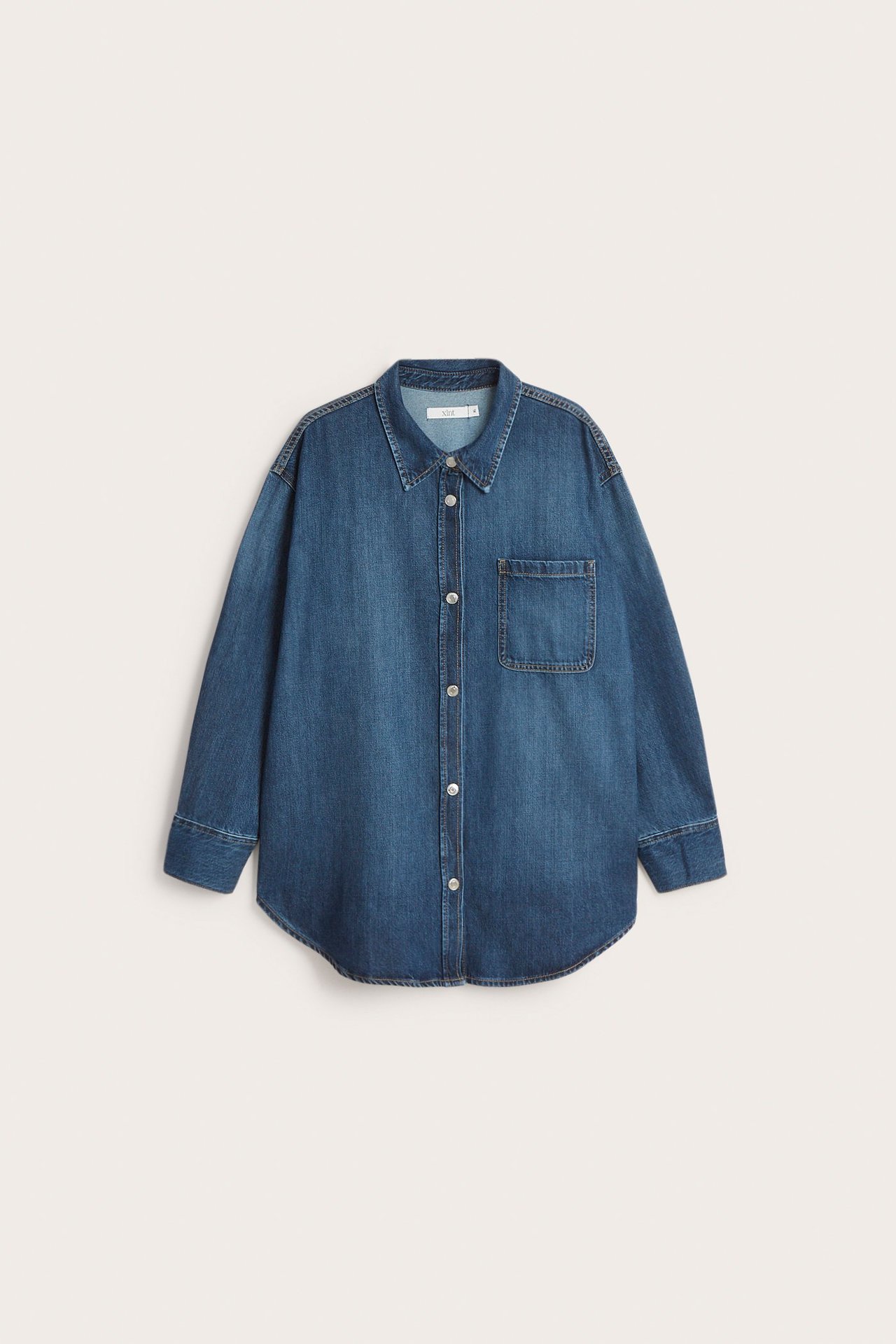 Edestä: Ylisuuri sininen farkkupaita rintataskulla ja painonapeilla.