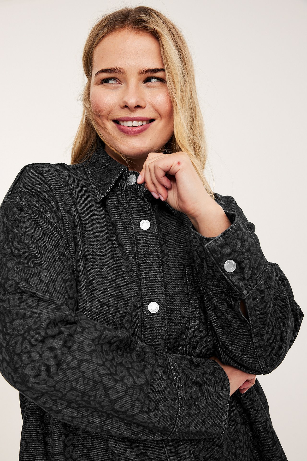 Kvinne i grå jeansskjorte med leopardmønster, lommer og trykknapper, frontvisning.
