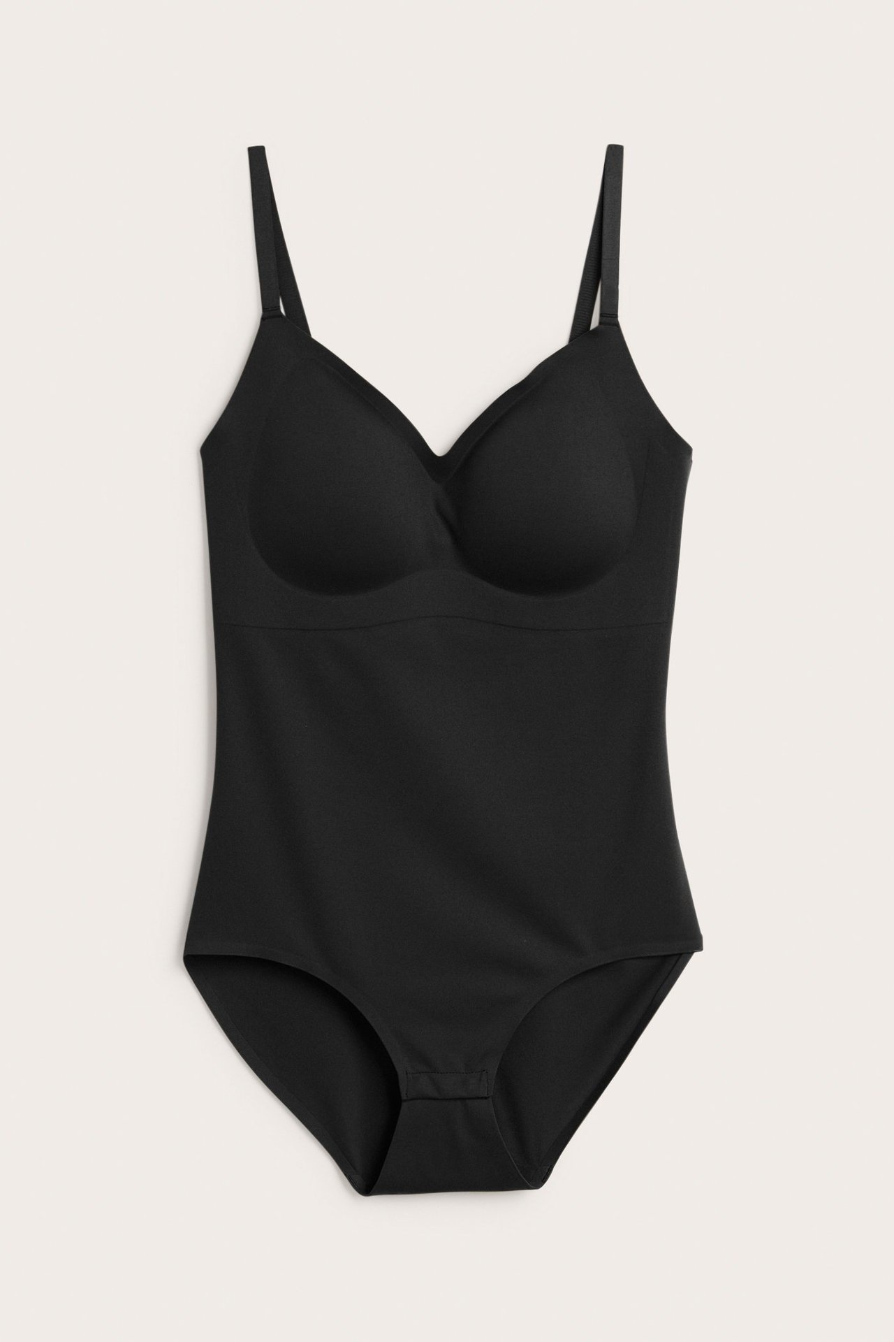 Edestä näkymä mustasta pehmeästä bodysta, jossa säädettävät olkaimet, pehmustetut kupit ja haarakiinnitys, saumaton tuntu.