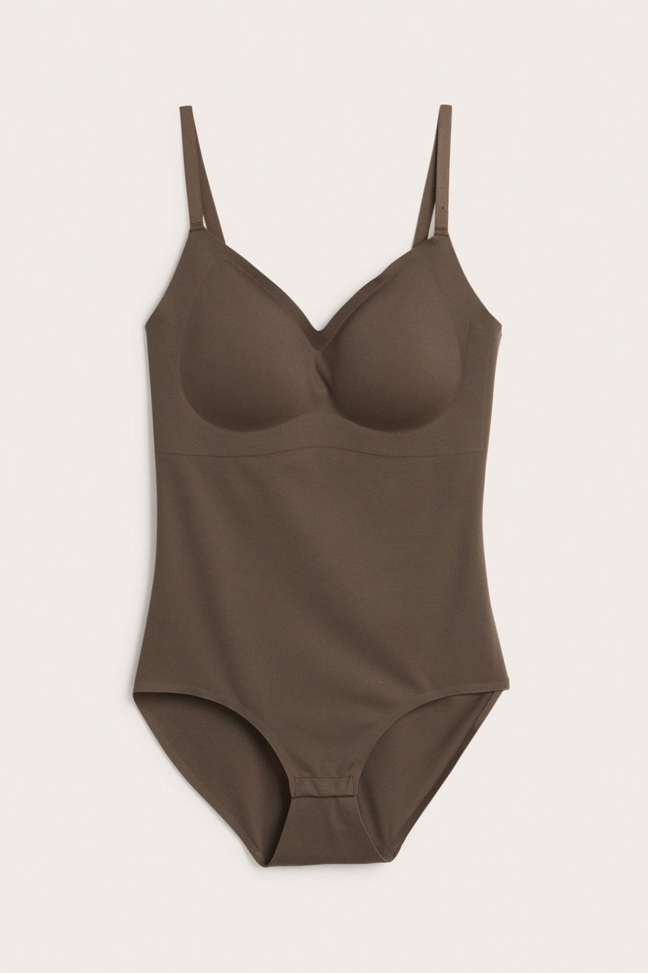 Frontvy av en mörkbrun mjuk body med justerbara axelband, vadderade kupor och knäppning i grenen.