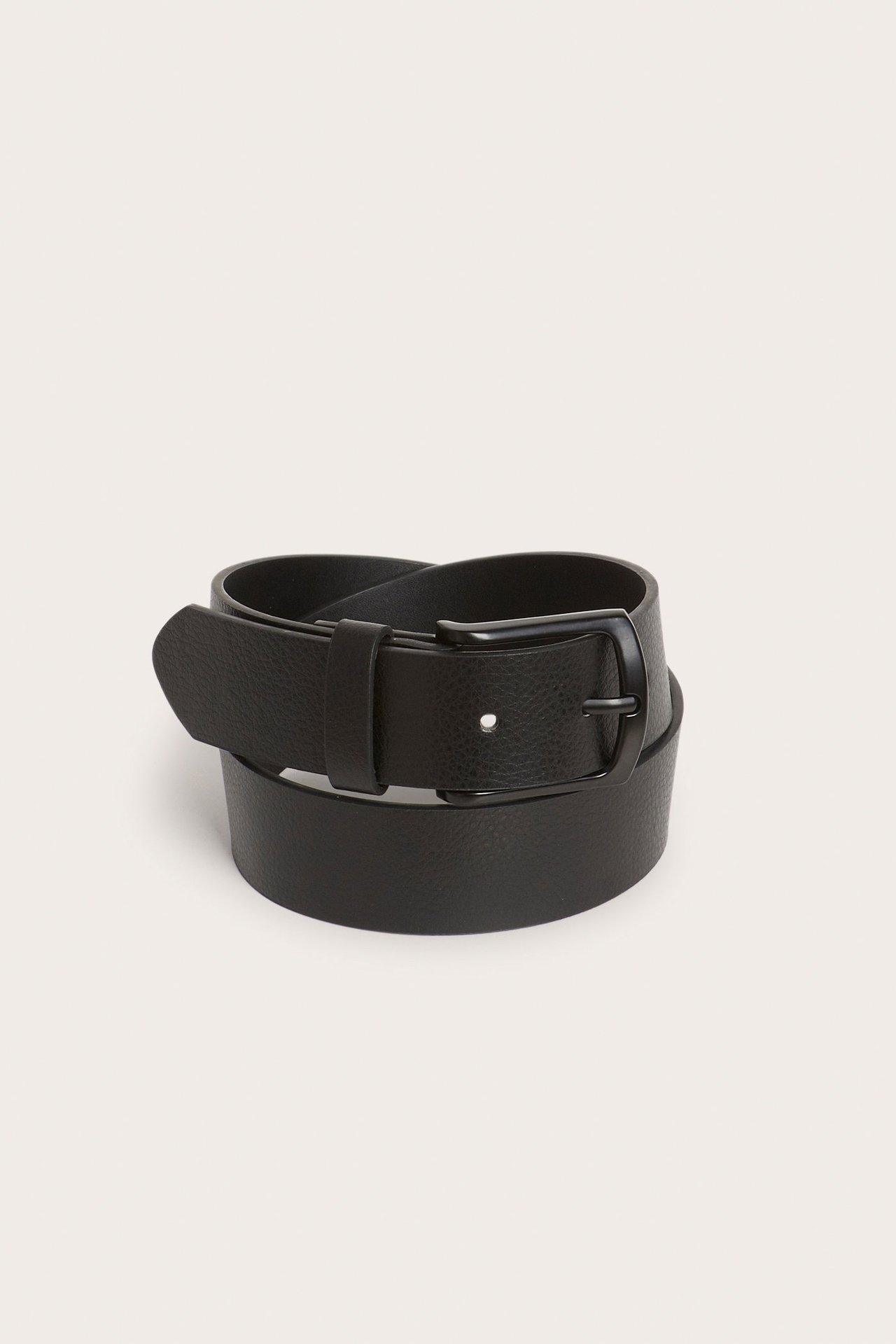 Lähikuva mustasta PU-vyöstä, jossa on musta metallisolki, kierretty valkoisella taustalla.