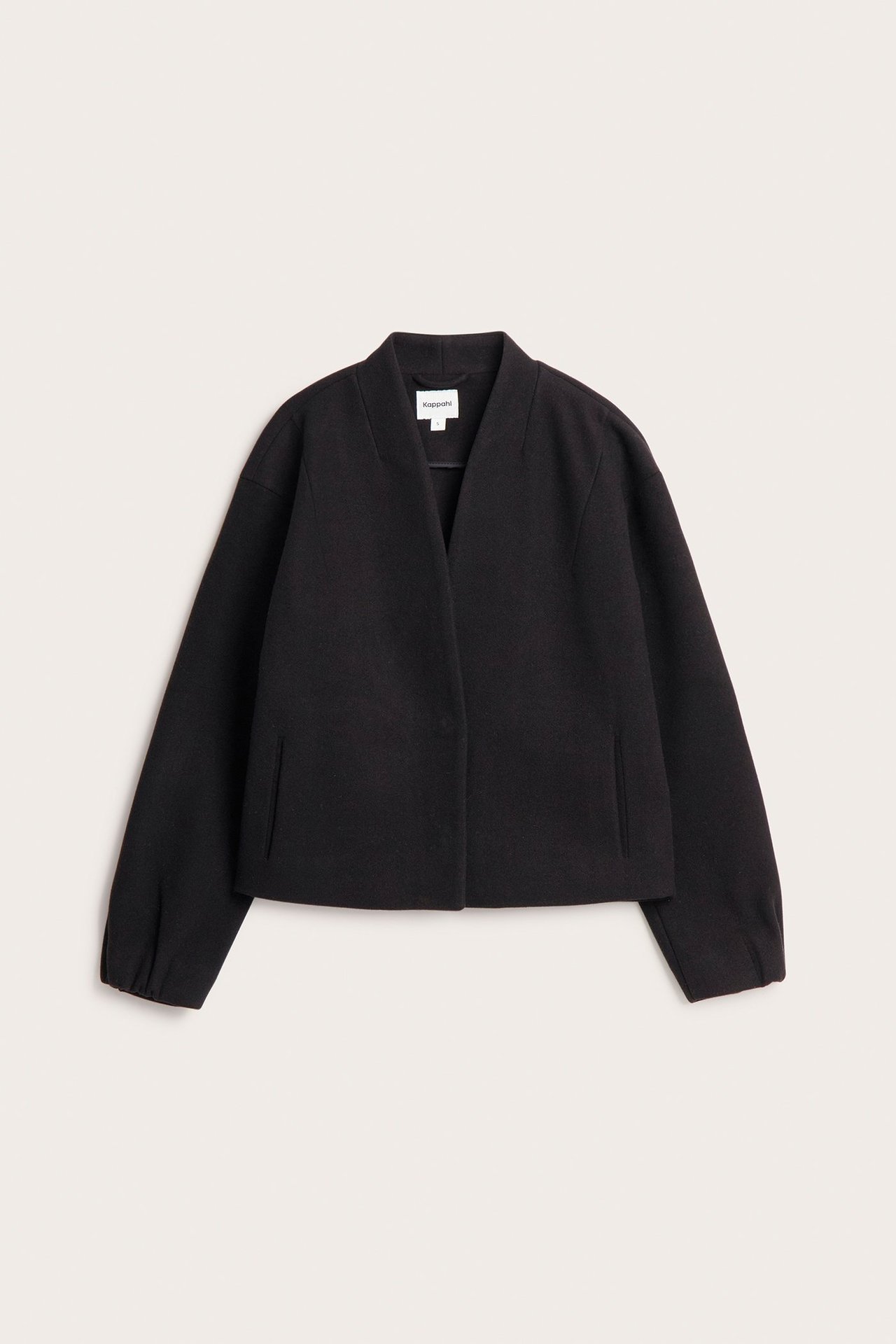 Widok z przodu: czarna, wełnopodobna krótka kurtka z dekoltem V, ukrytymi zatrzaskami i kieszeniami.