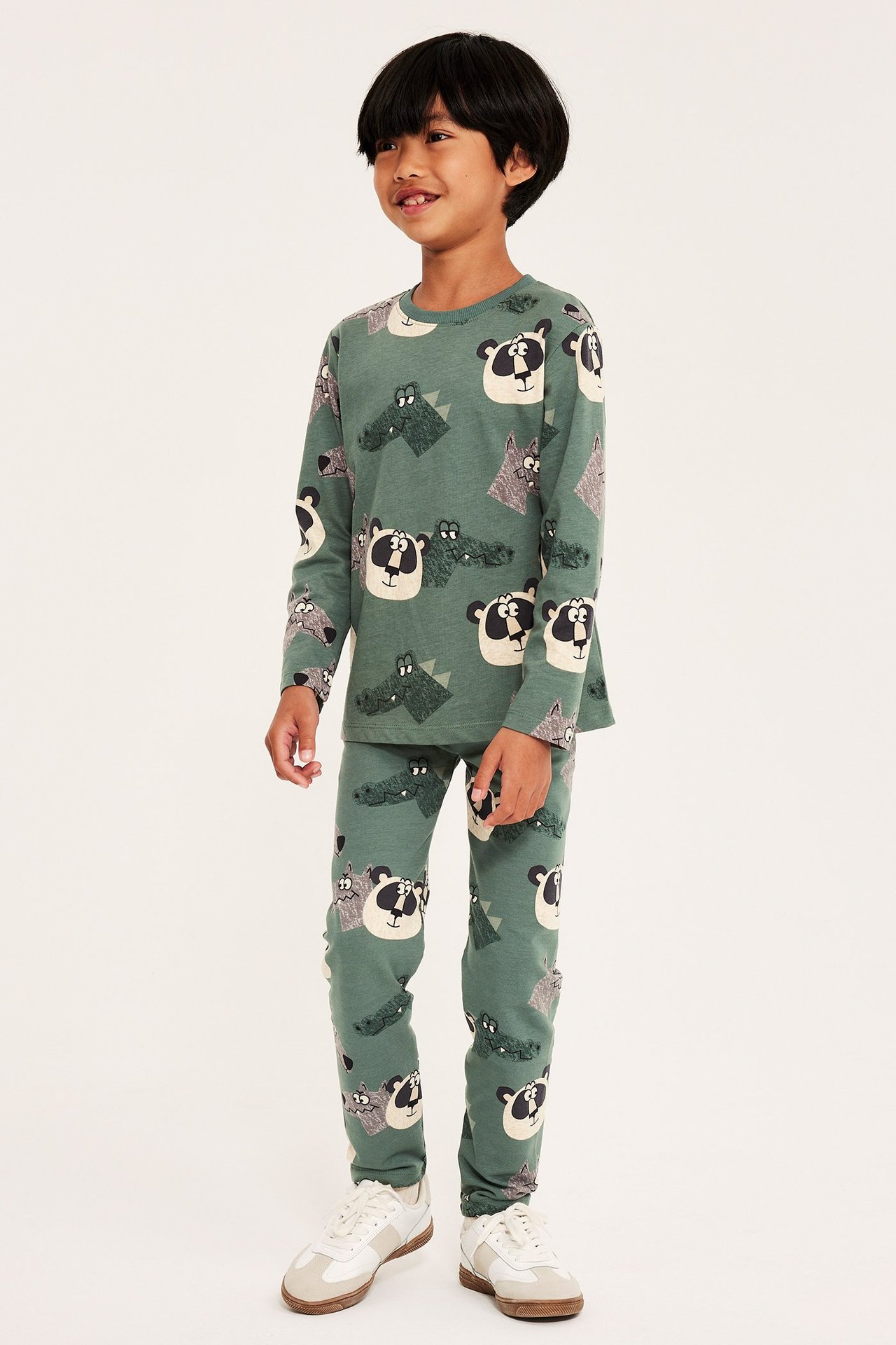 Frontvy av ett barn i mörkgröna bomullsleggings och matchande långärmad topp med djurmönster.