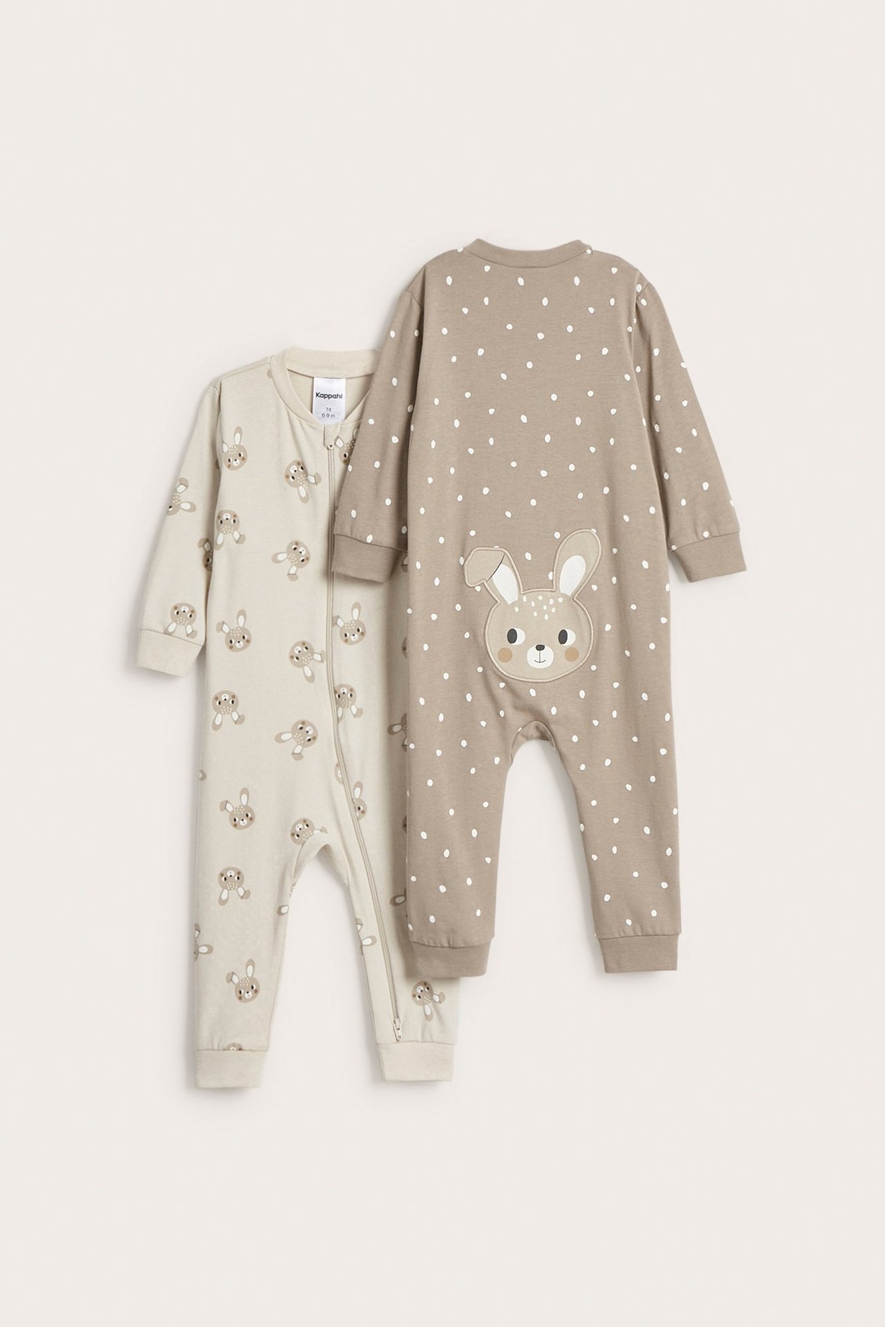 Två beiga babyrompers, framifrån: en med kaninmönster och dragkedja, den andra prickig med kaninapplikation bak.