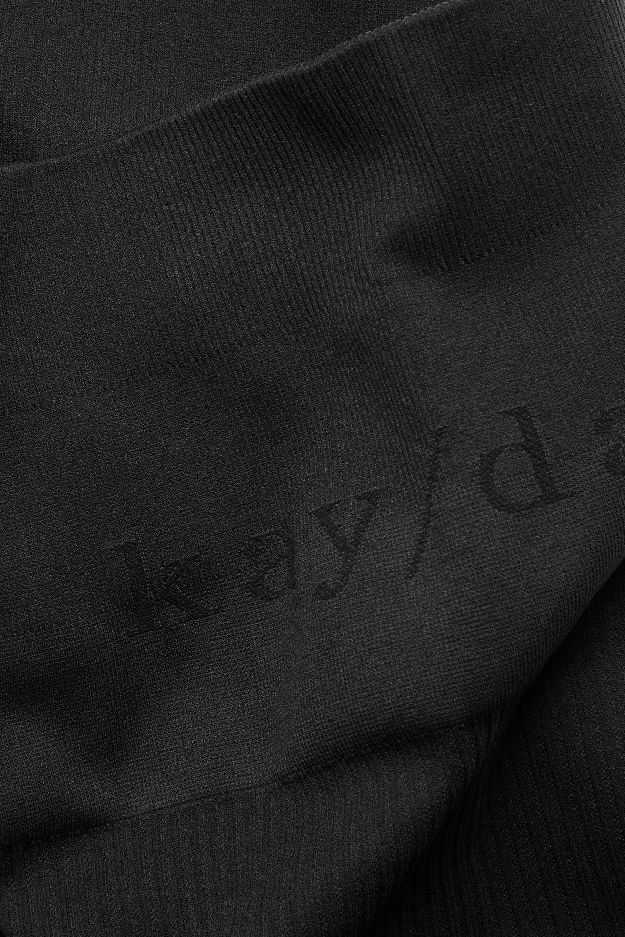 Zbliżenie czarnych, bezszwowych szortów rowerowych z subtelnym logo kay/day.