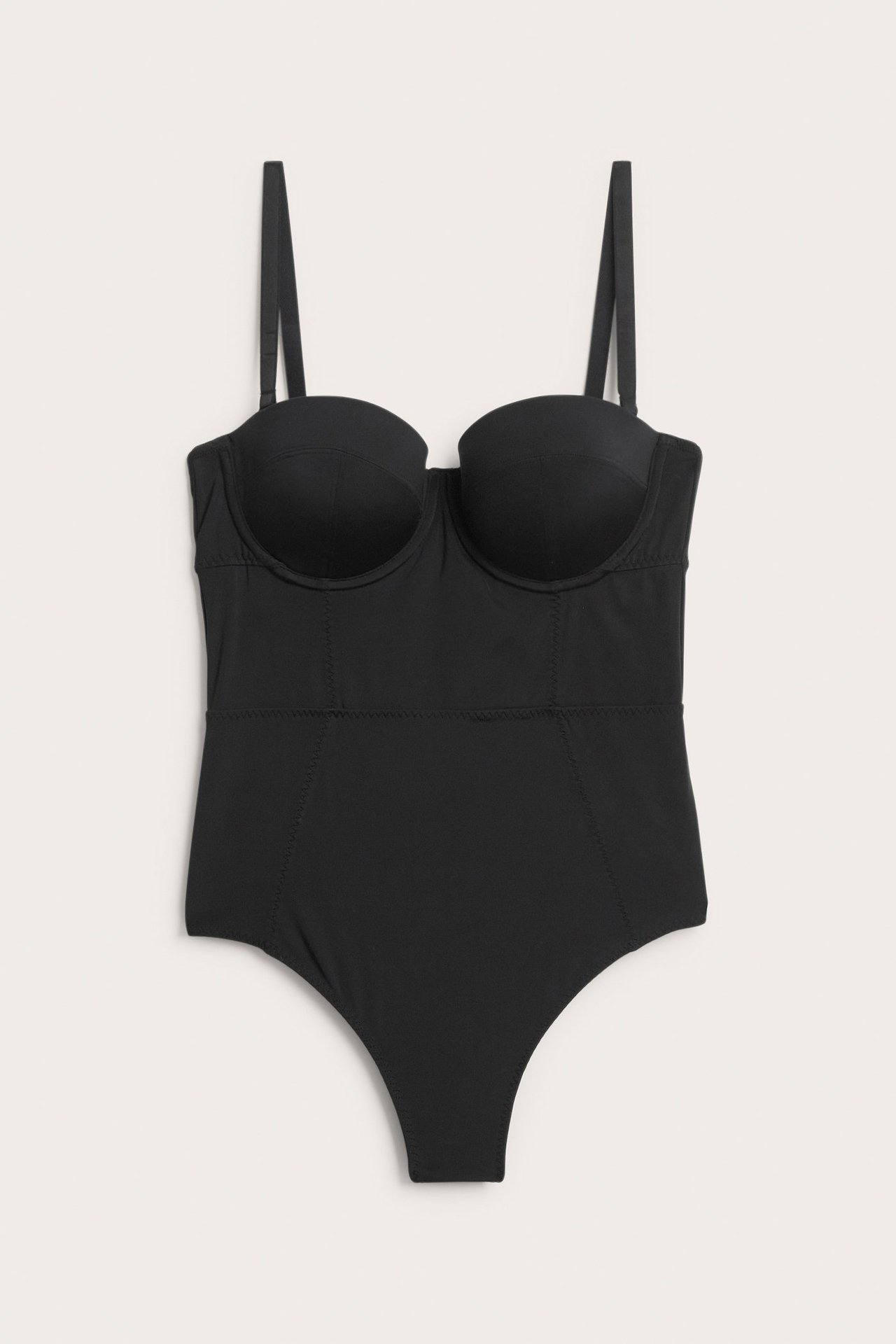 Frontvisning av en svart formende body med cuper, justerbare stropper og detaljerte sømmer.