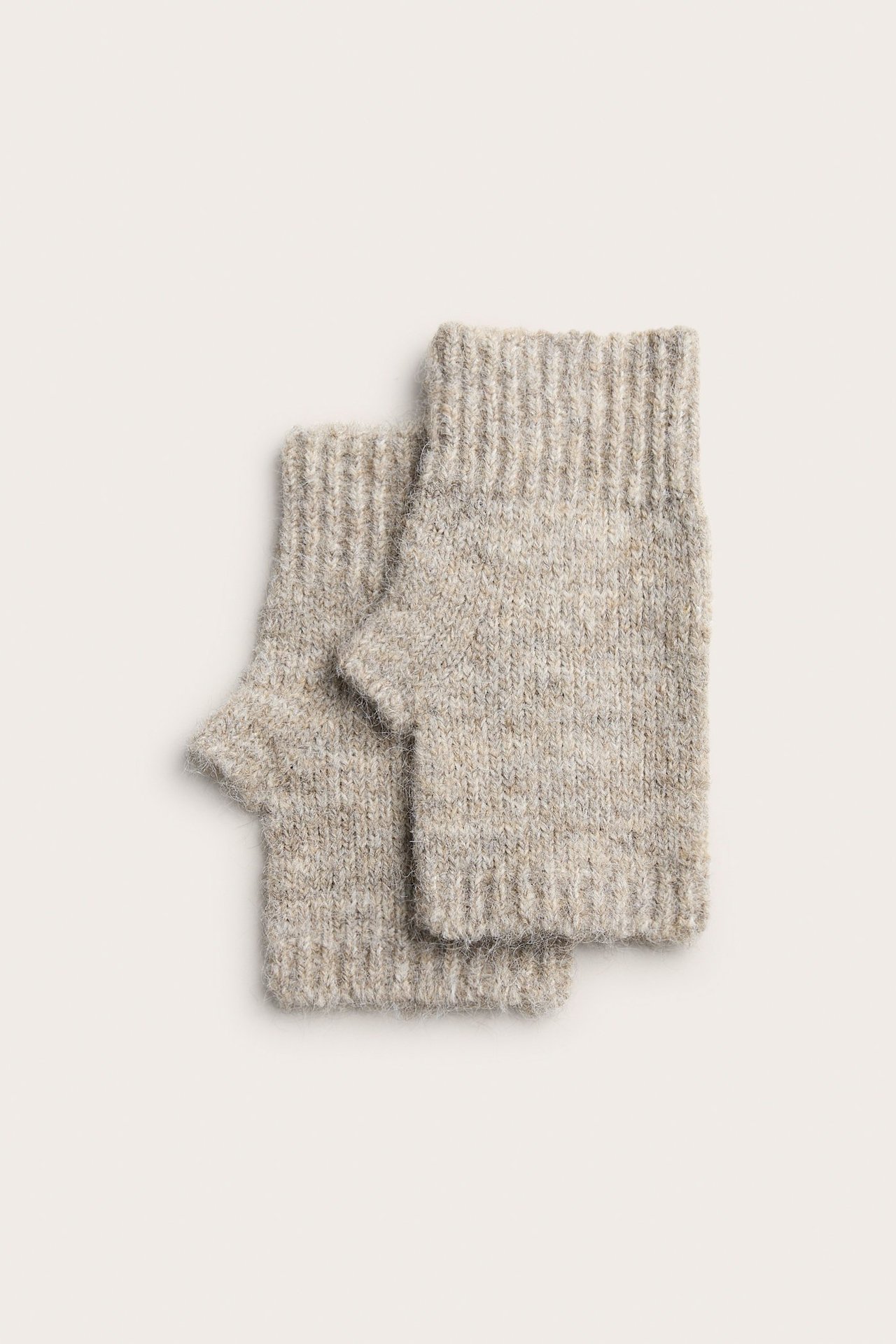 Widok z góry na parę beżowych melanżowych, prążkowanych ocieplaczy na nadgarstki z otworami na kciuki.
