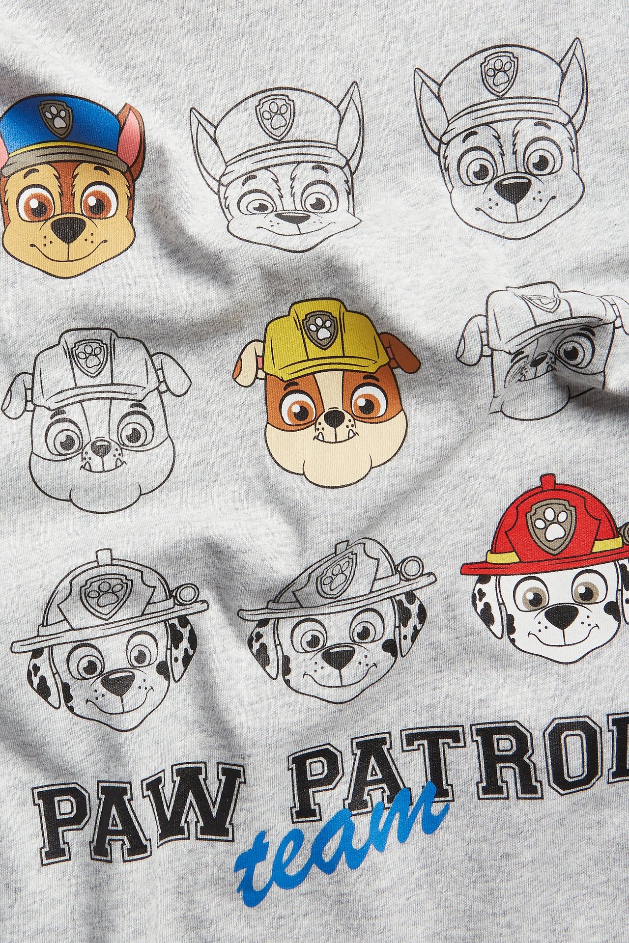 Närbild på en ljusgrå bomulls-t-shirt för barn med stort Paw Patrol-tryck framtill.
