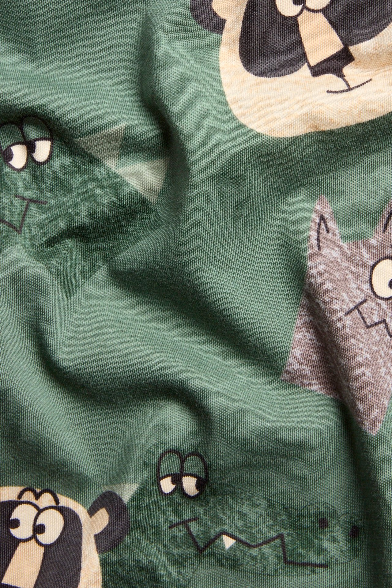 Zbliżenie na ciemnozieloną bawełnianą koszulkę z długim rękawem z zabawnym zwierzęcym nadrukiem.