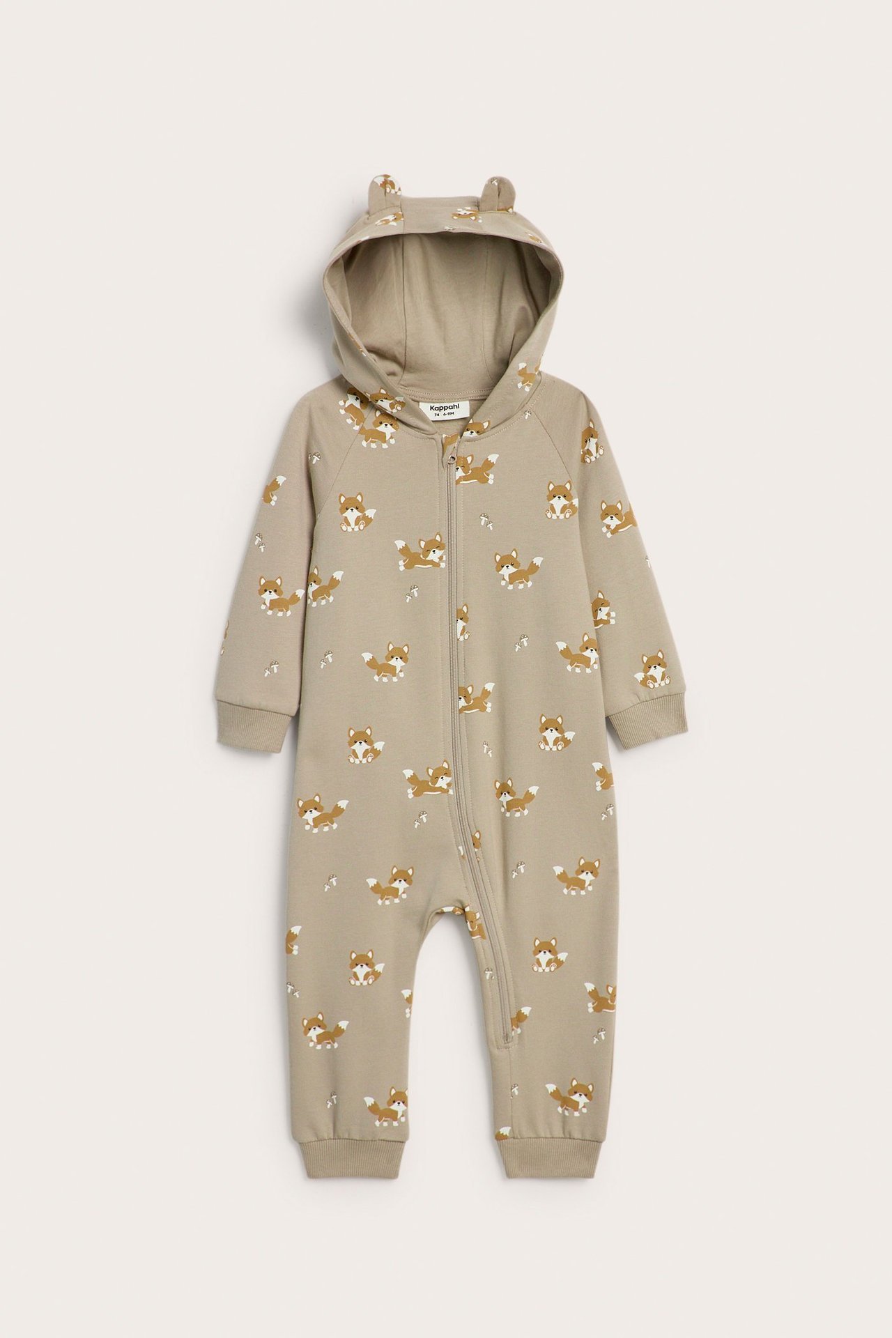 Edestä näkymä beigestä vauvan haalarista, jossa kettupainatus, huppu korvilla ja vetoketju edessä.