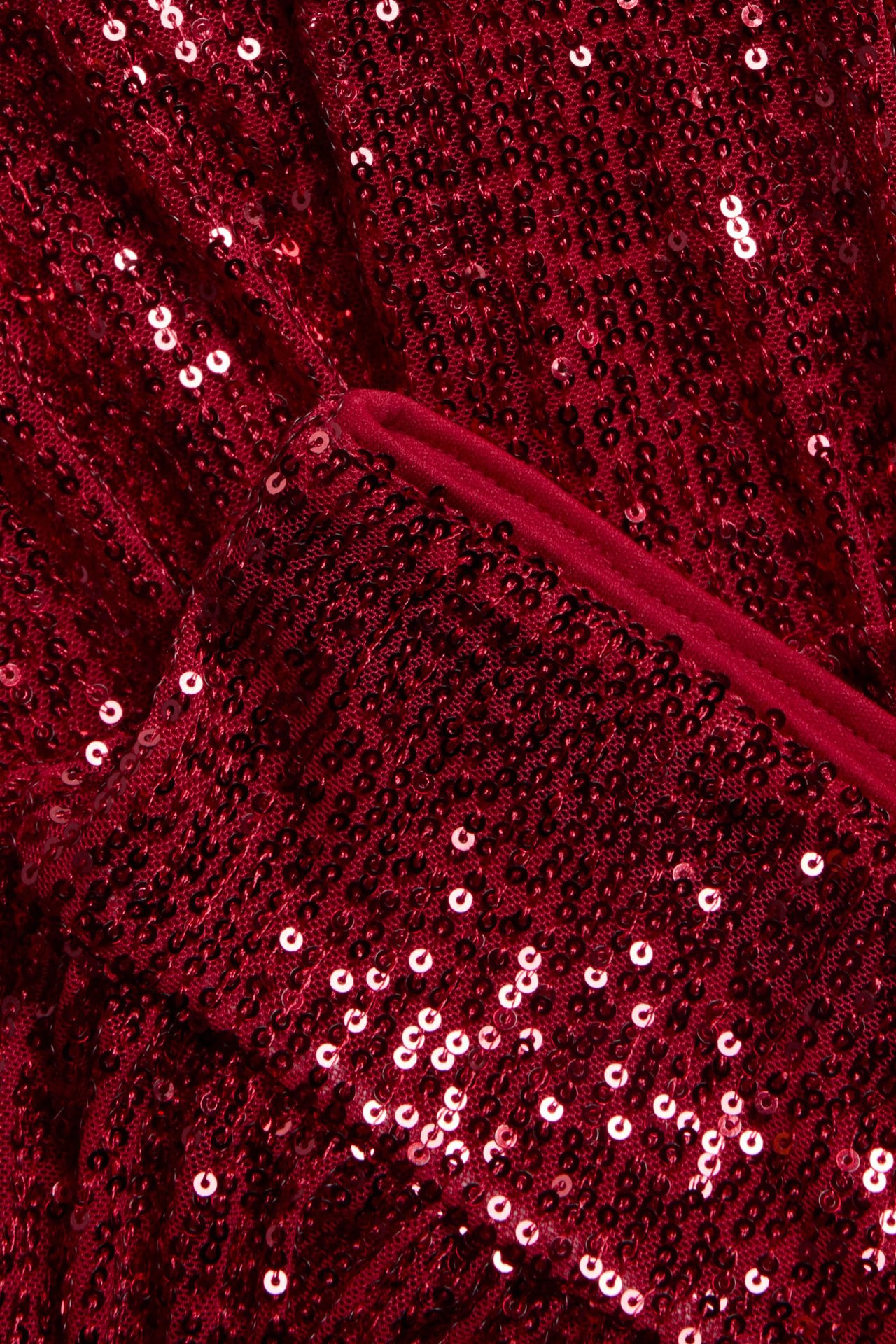 Zbliżenie na czerwoną dziecięcą spódnicę z falbanami i cekinami, z elastyczną talią.