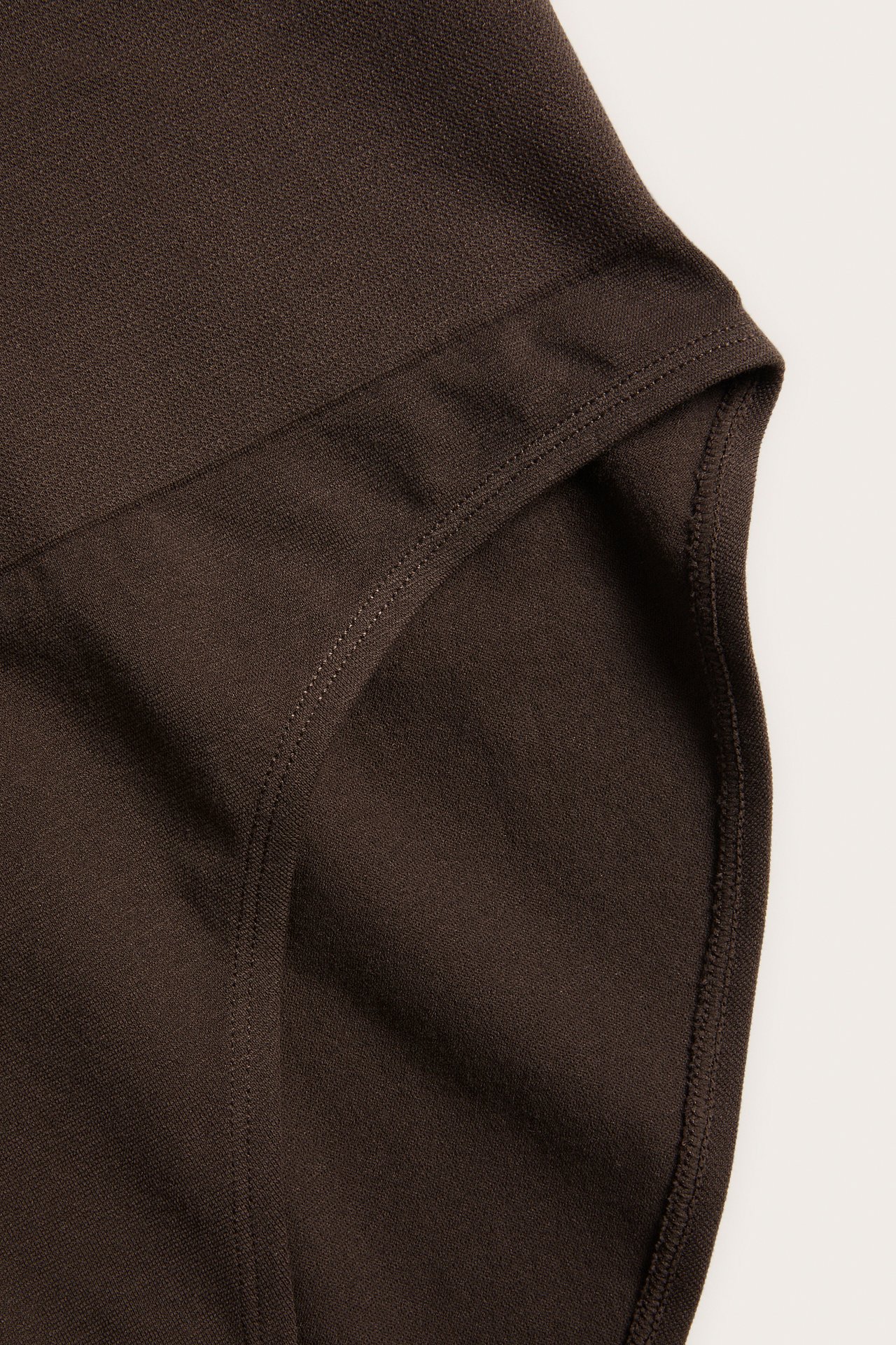 Närbild av mörkbrun sömlös trosa i briefmodell med hög, ribbad midja.