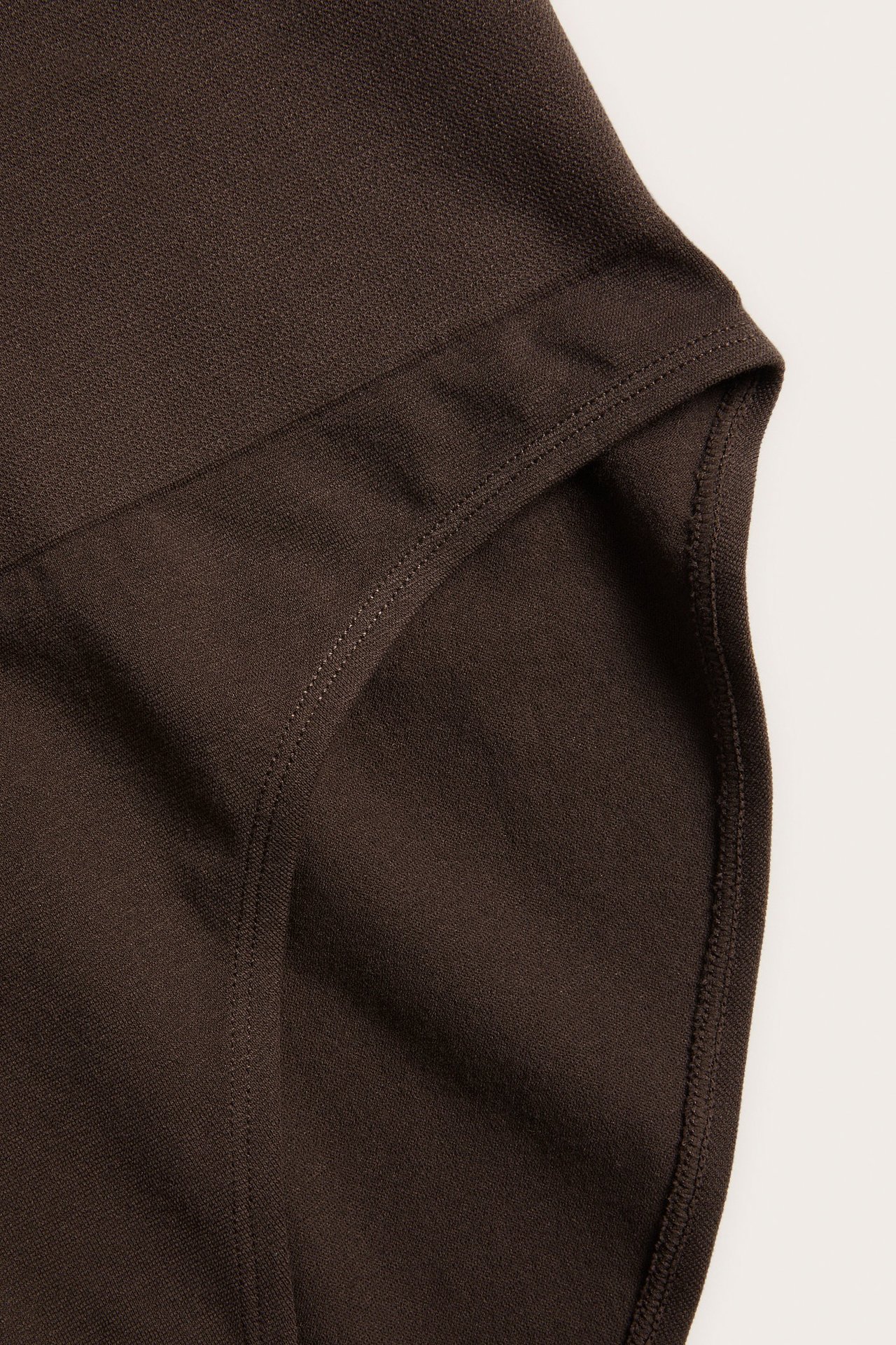 Zbliżenie na ciemnobrązowe, bezszwowe figi z wysokim, prążkowanym pasem.