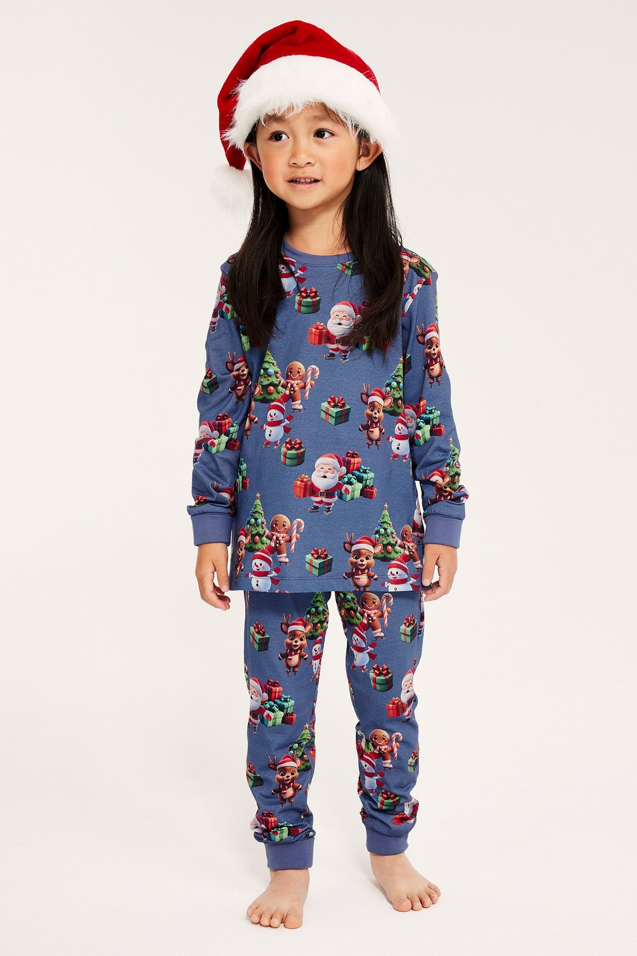 Jente i julepyjamas med nissemønster, blå, bomull, brette mansjetter, elastisk midje, front.