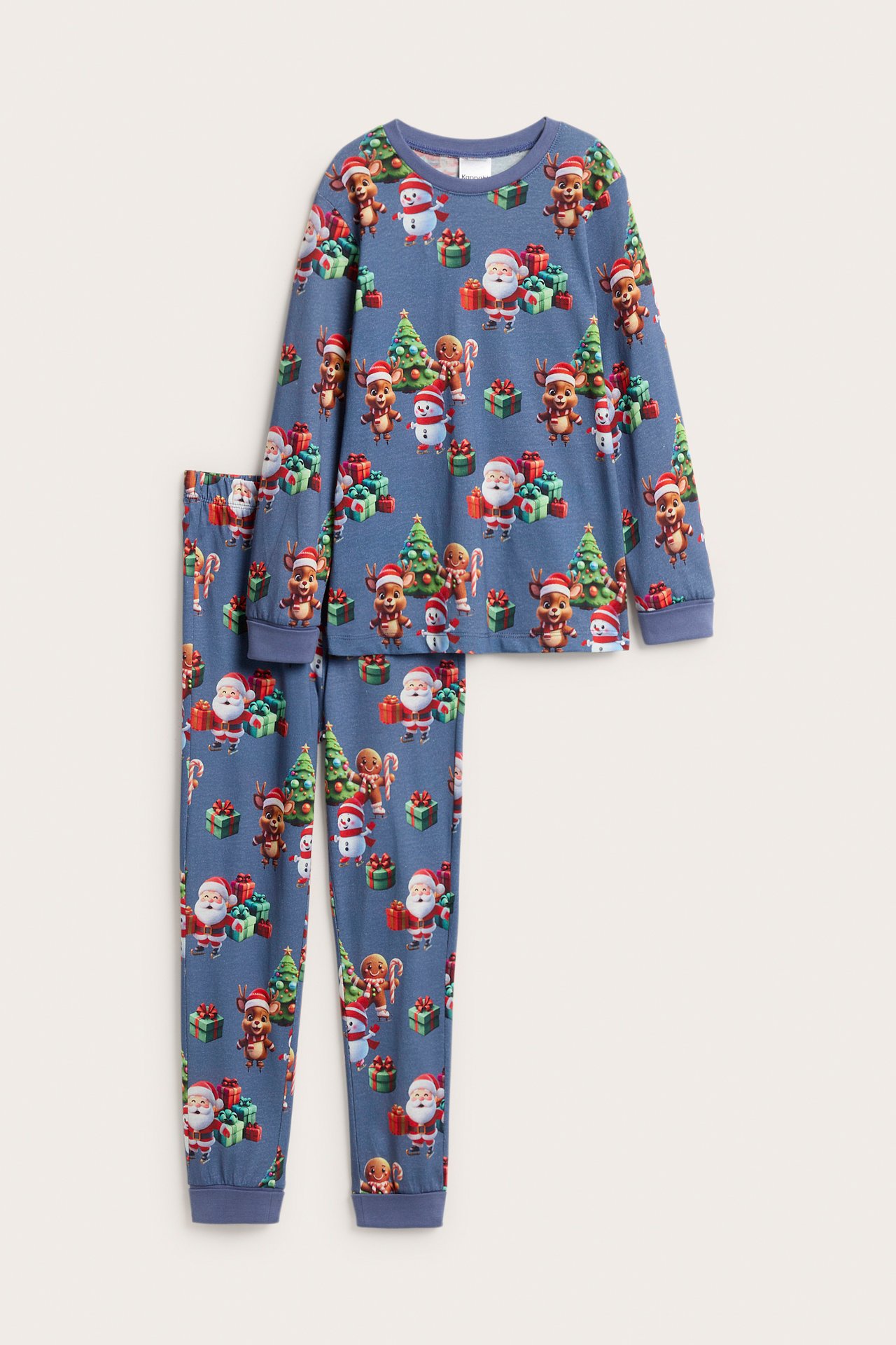 Frontvy av en blå julpyjamas i bomull för barn med festligt mönster av tomtar och renar.