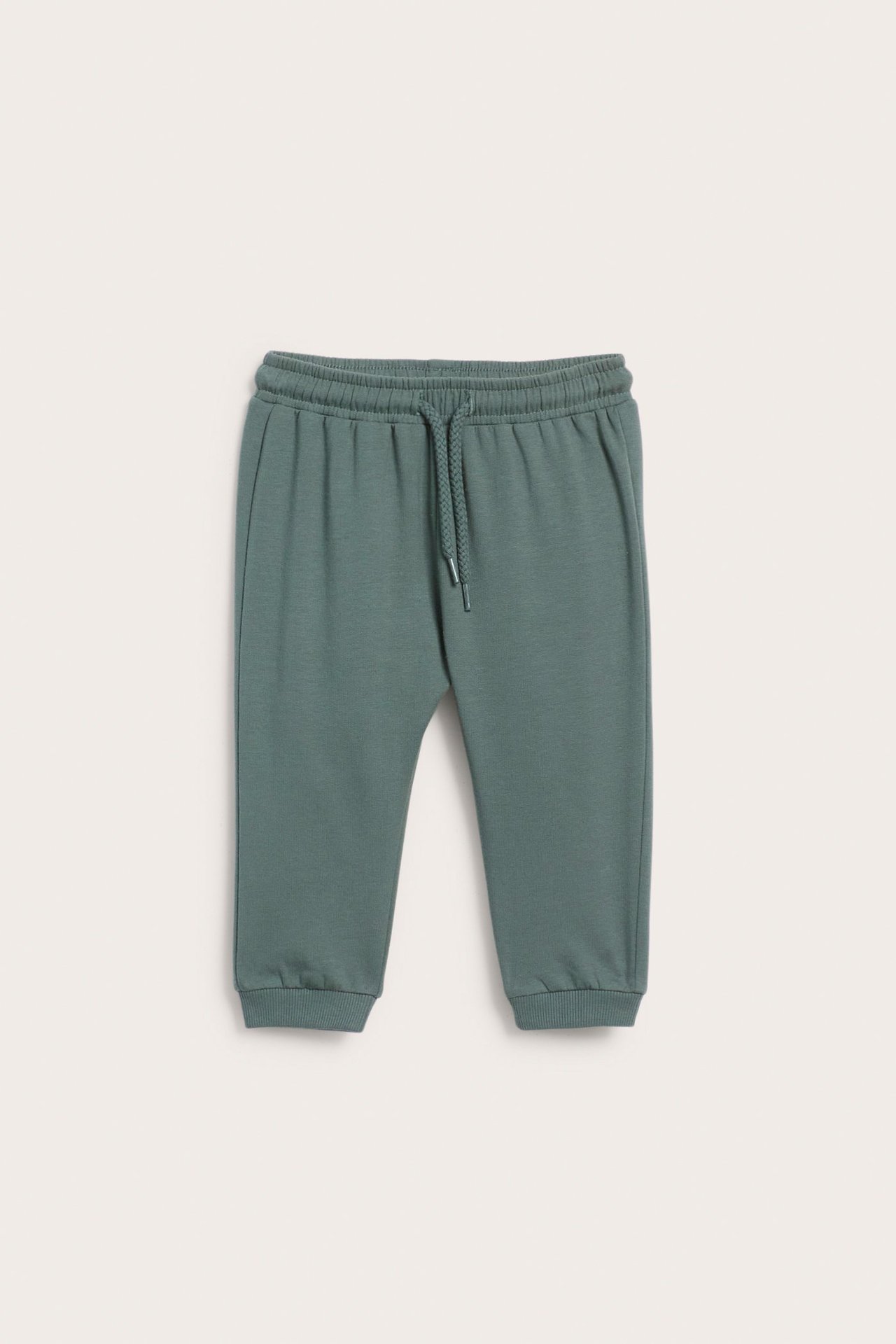 Edestä kuvatut vauvan khakinvihreät collegehousut, joissa joustava vyötärö ja kiristysnyöri.