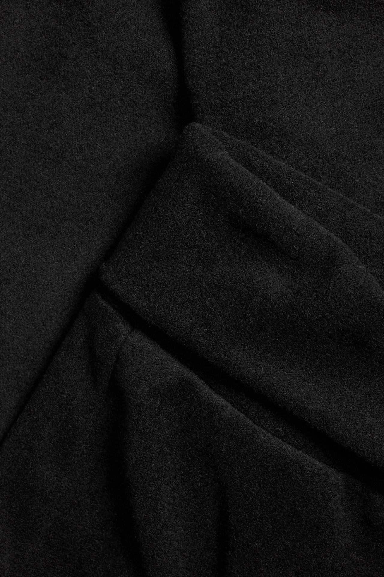 Zbliżenie na czarny, miękki materiał, prawdopodobnie z ocieplanych rozszerzanych spodni do jogi.