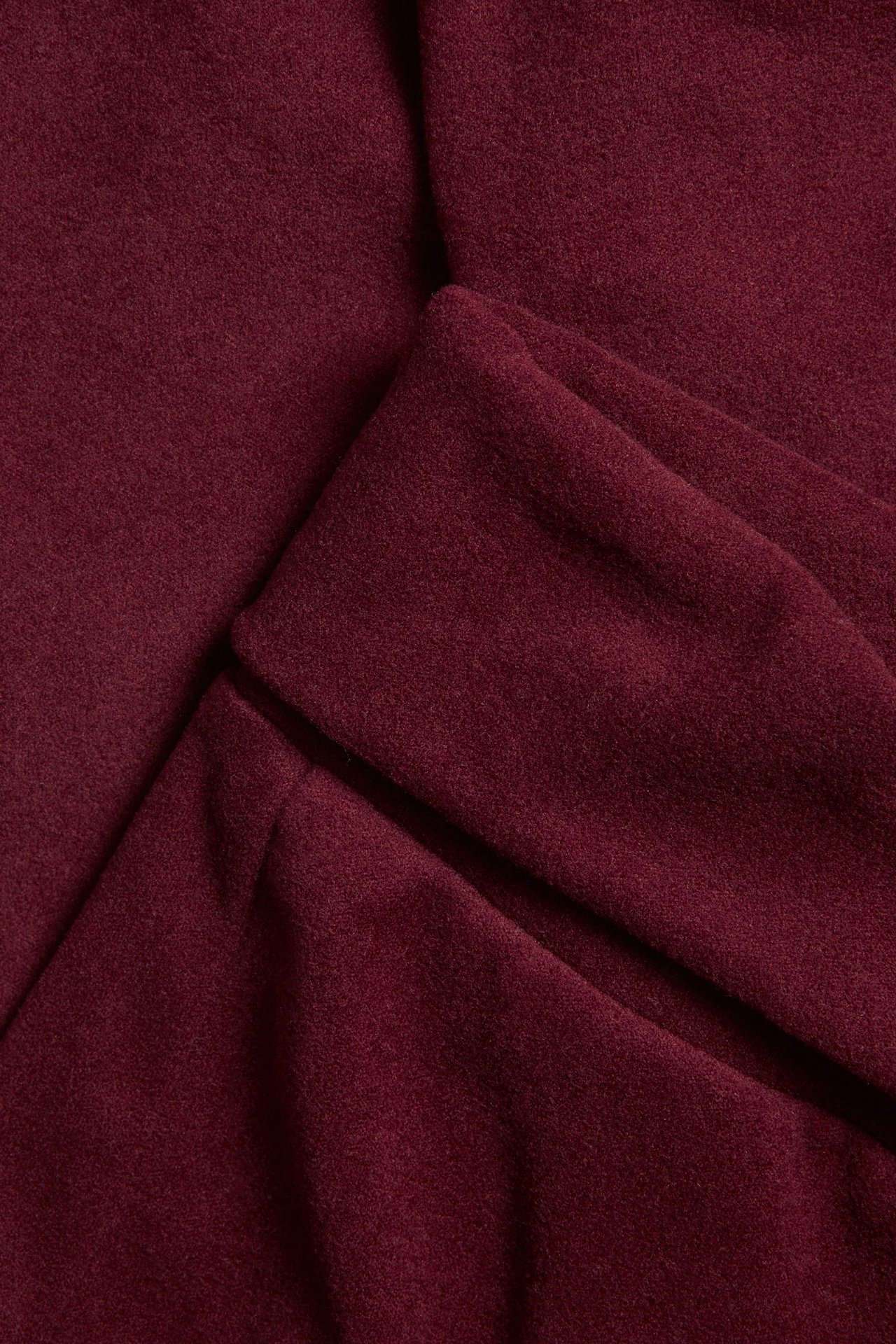 Zbliżenie na ciemnoczerwone legginsy, ukazujące materiał i wywijany pas.