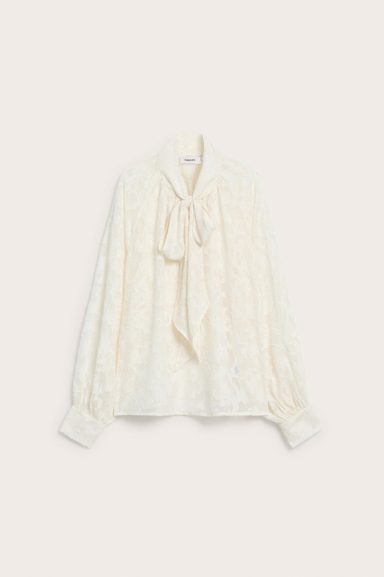 Widok z przodu: Ecru koronkowa bluzka z wiązaną kokardą pod szyją i długimi marszczonymi rękawami.