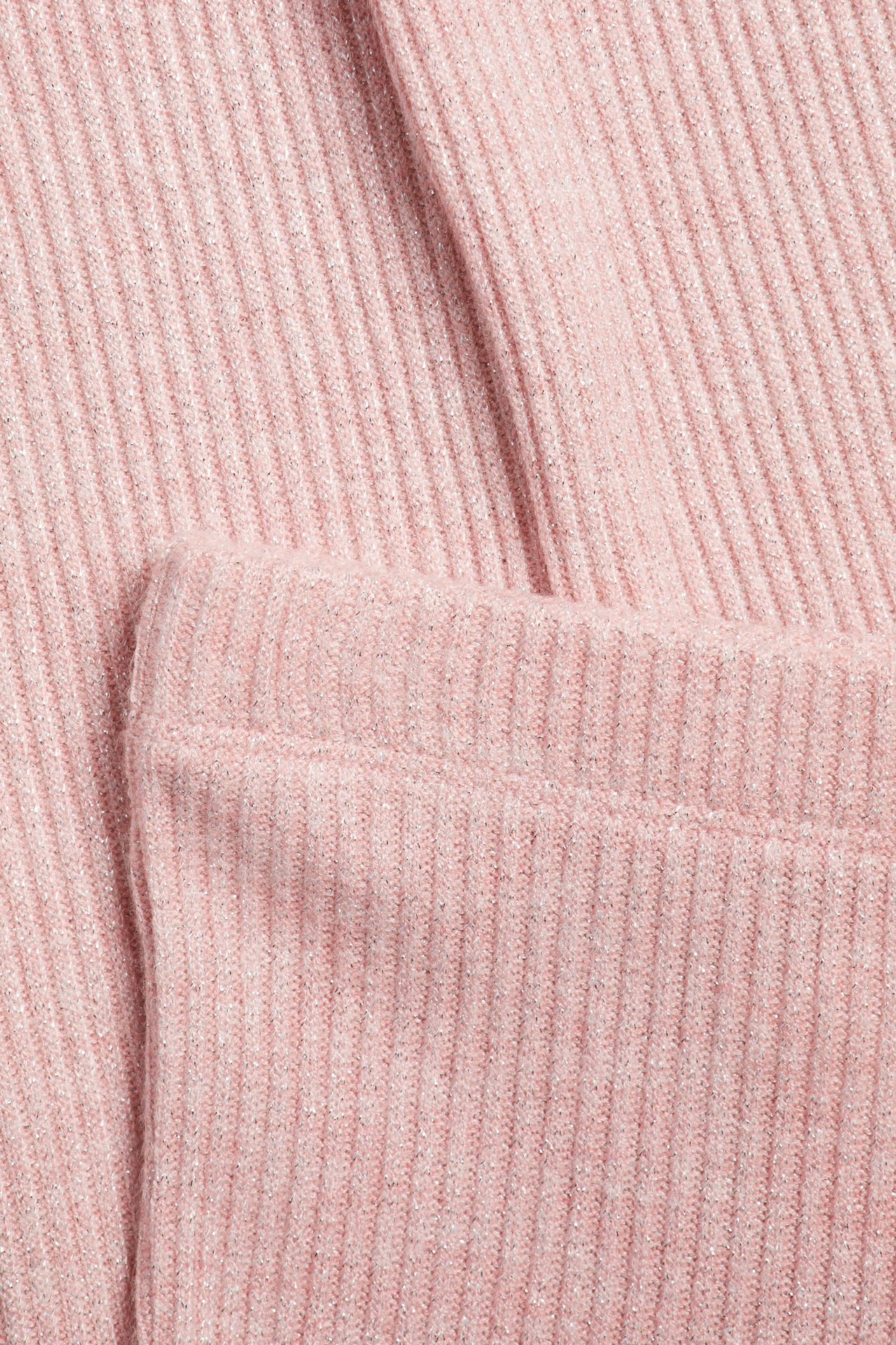 Zbliżenie jasnoróżowych, brokatowych legginsów w prążki.