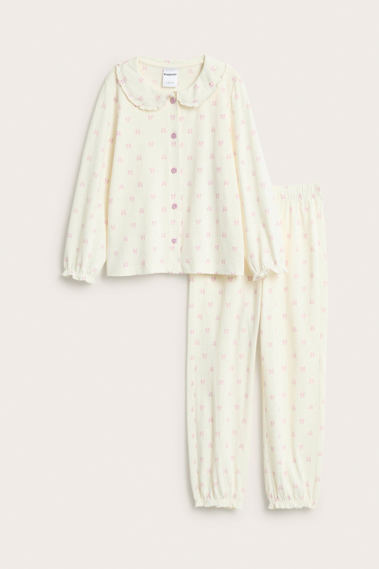 Kremowa piżama dziecięca z bawełny, z różowymi kokardkami, falbankowym kołnierzem i guzikami.
