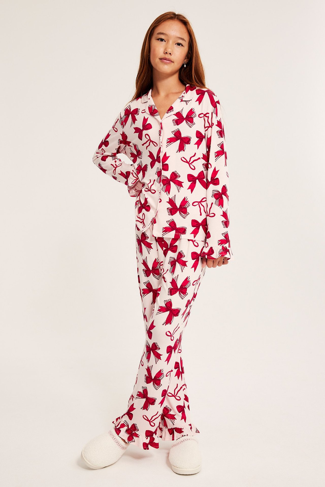 Nainen vaaleanpunaisessa, kuviollisessa pitkähihaisessa puuvillapaitasetti, napit edessä.